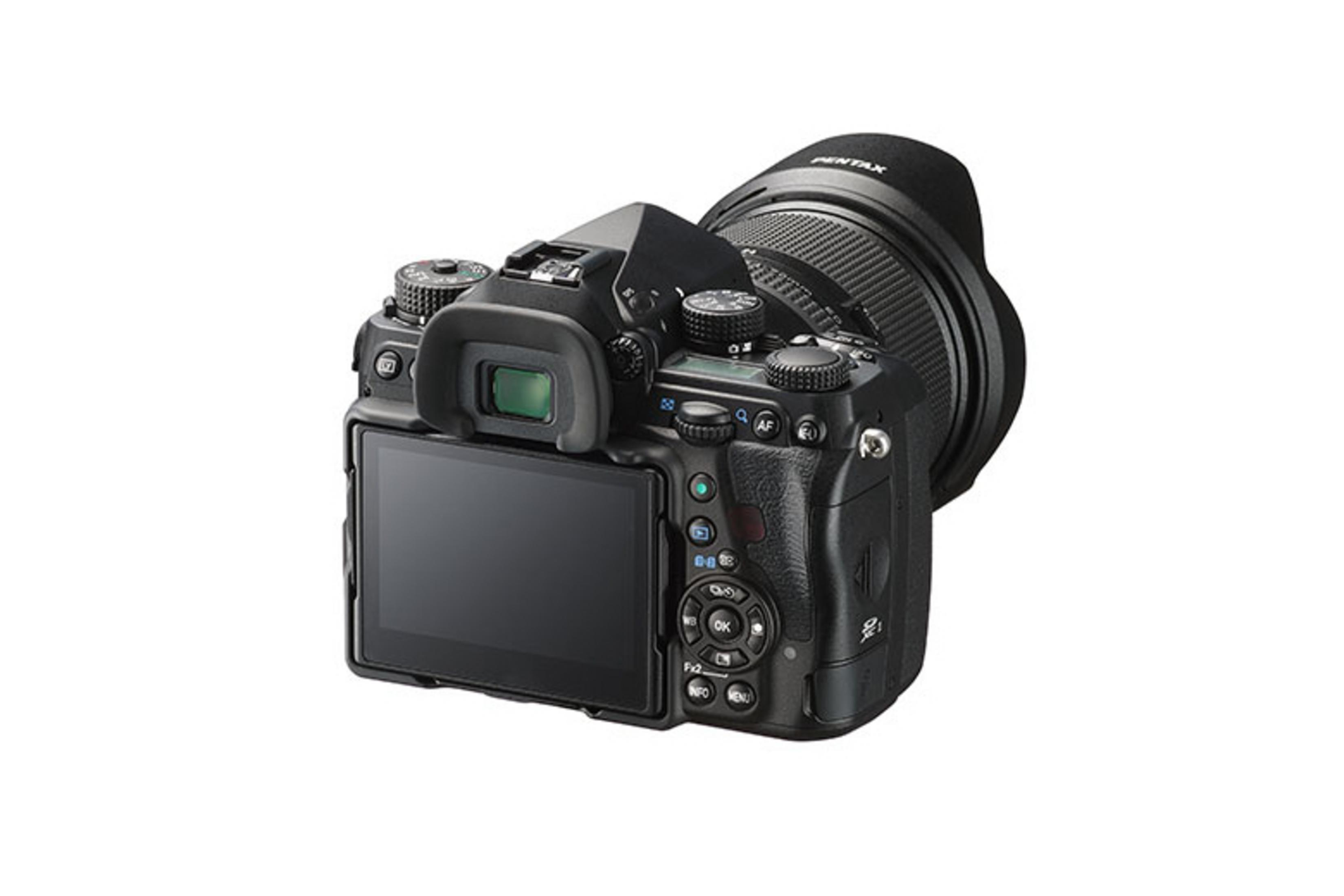 Een zwarte Pentax-camera met een lens op een witte achtergrond. Het scherm is zichtbaar. De lens heeft de merknaam.