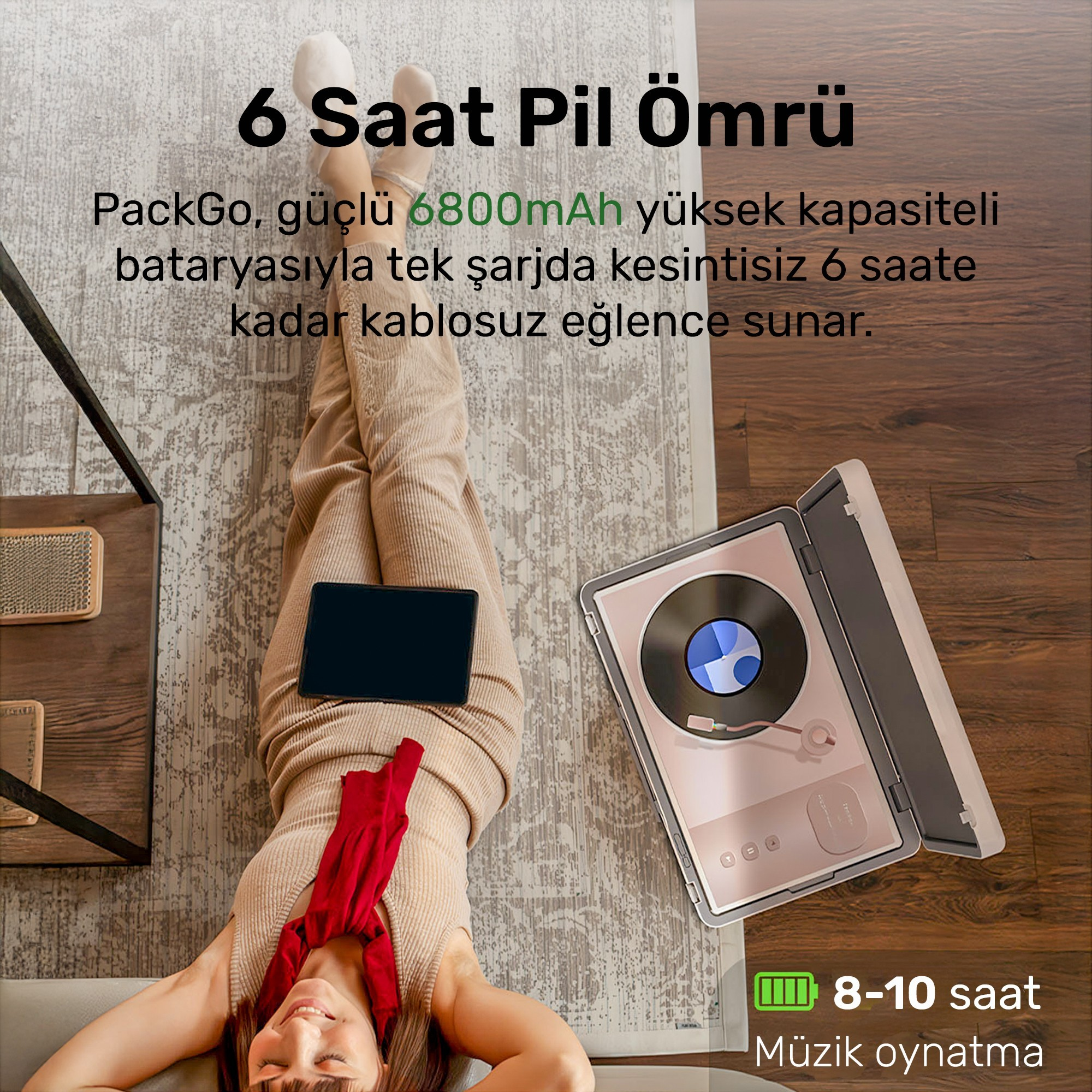 Ahşap zeminde tablet ve pembe plak çalar ile yatan kadın.