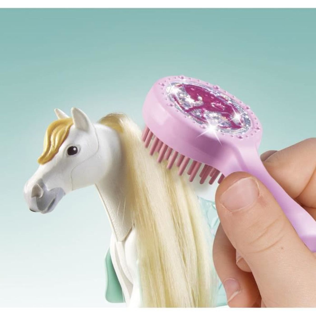 Eine Hand bürstet ein weißes Spielzeugpferd mit einer rosa Bürste. Das Pferd hat eine gelbe Mähne und einen Schweif.