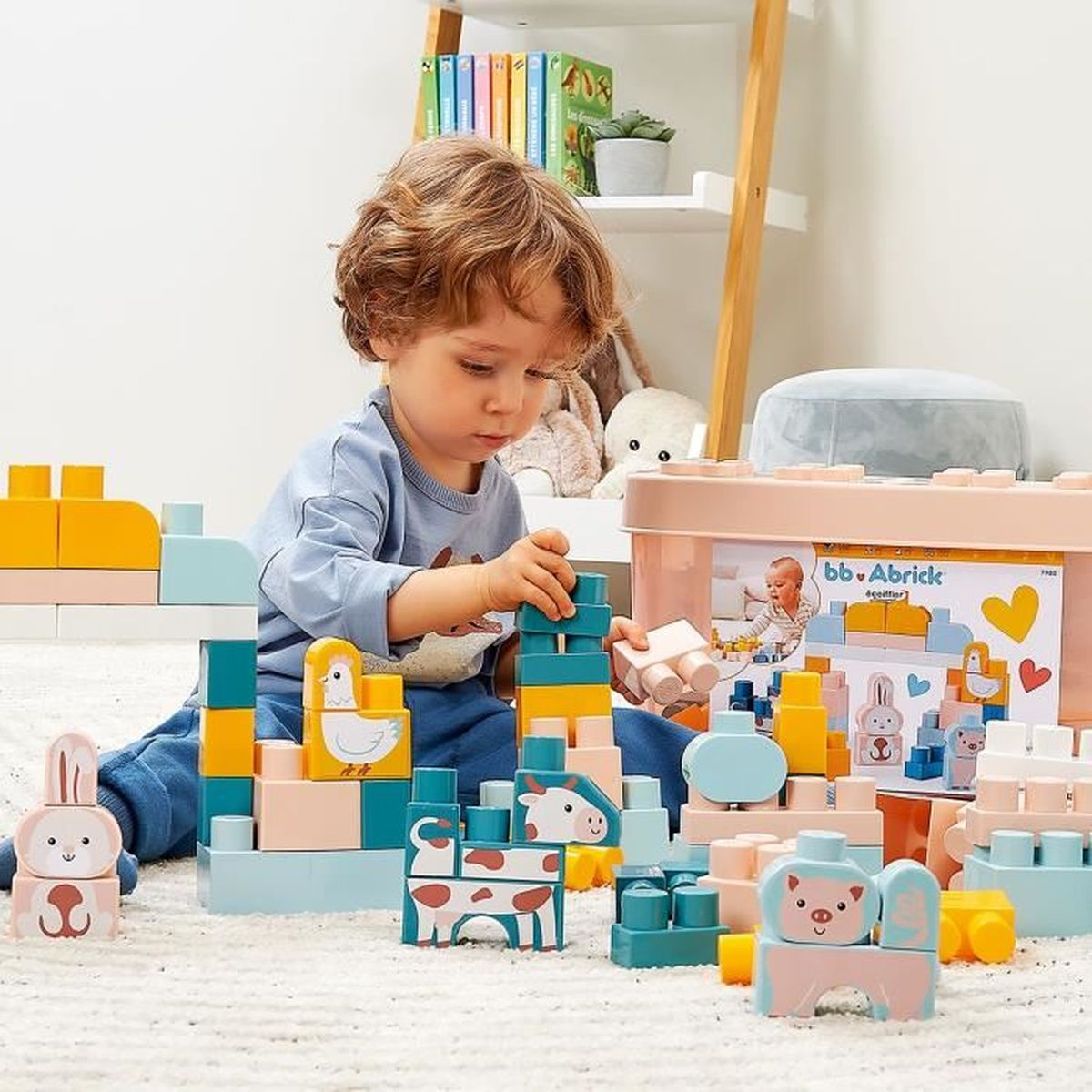 Un bambino gioca con blocchi di giocattoli colorati, costruendo torri e forme di animali. La scena è al chiuso, con una mensola e deposito giocattoli visibili.