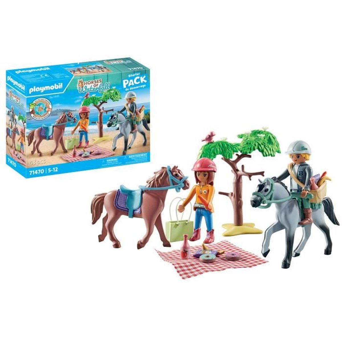 Un juego de Playmobil con caballos y jinetes. Incluye una escena de picnic con manta, comida y un árbol pequeño. Una caja está en el fondo.