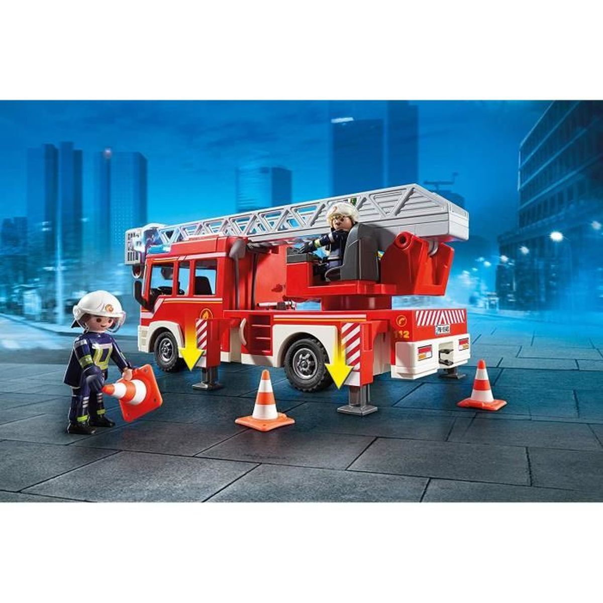 Ein rotes Feuerwehrauto-Spielzeug mit Leiter, zwei Spielzeug-Feuerwehrleuten und Verkehrskegeln vor blauem Hintergrund.