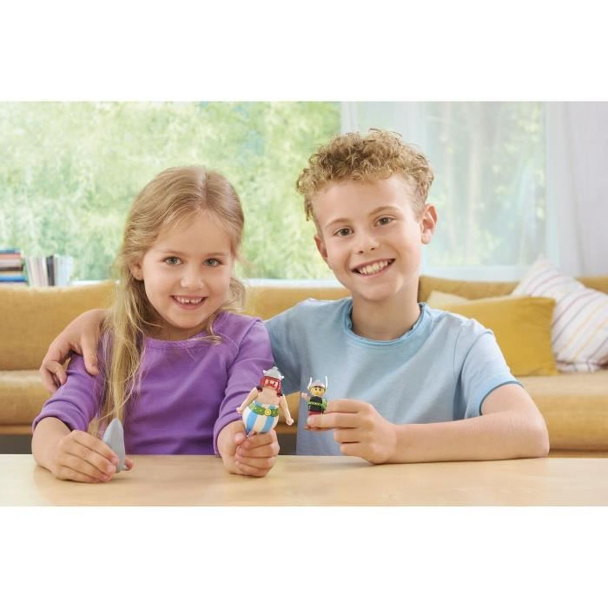 Dwoje uśmiechniętych dzieci trzymających figurki. Dziewczyna trzyma szary przedmiot. Chłopiec obejmuje dziewczynę.