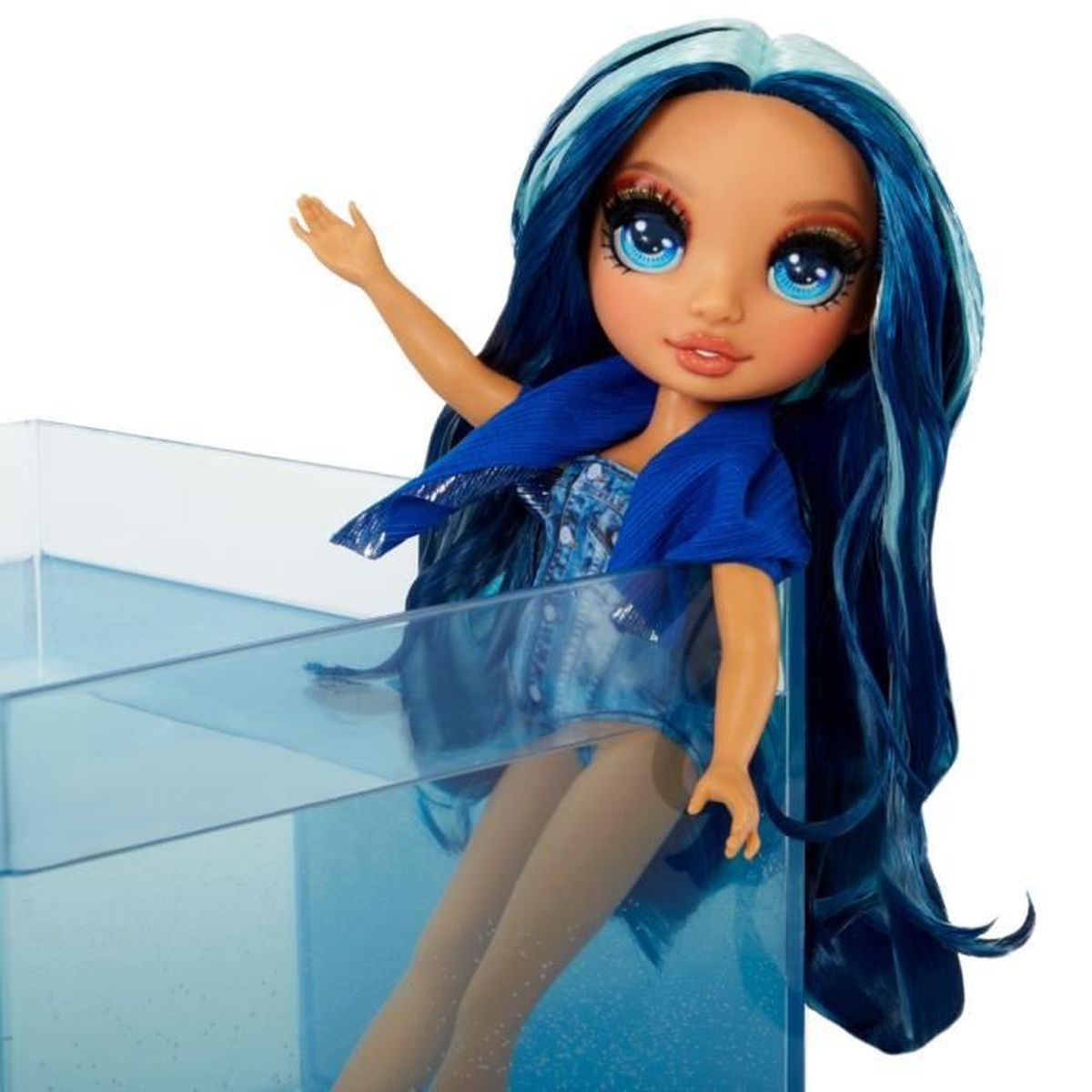 Una muñeca con cabello y ojos azules, vestida con un atuendo azul, está sentada en un recipiente azul transparente lleno de agua.