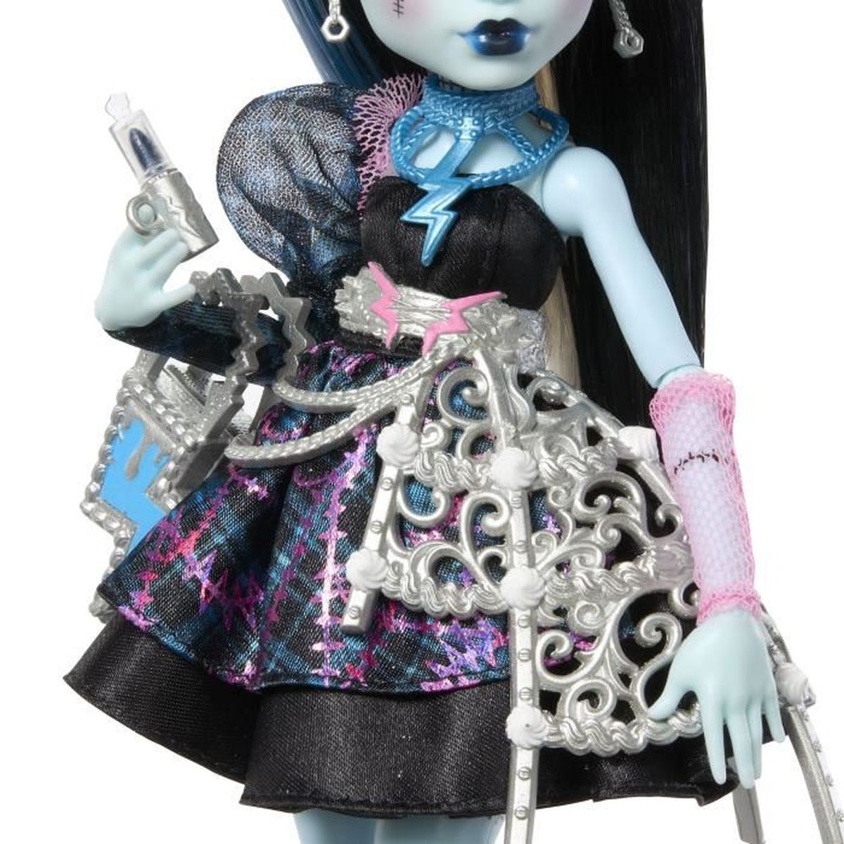 Primer plano de una muñeca Monster High con piel azul, vestida con un vestido. Sostiene una jeringa y un bolso. El vestido es negro y a cuadros.
