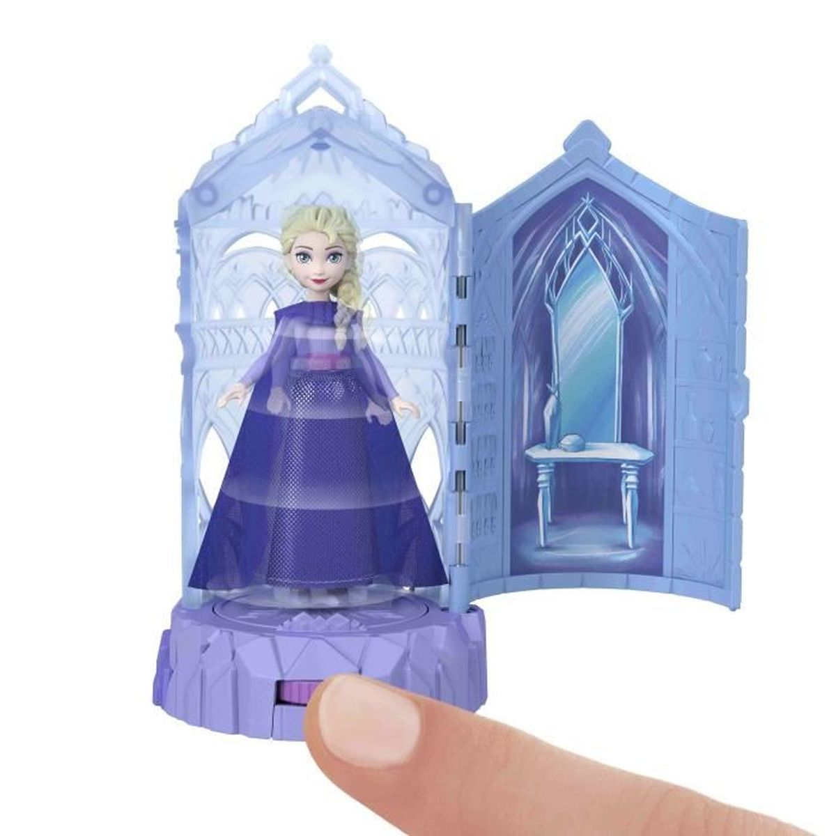 Muñeca Elsa con vestido azul dentro de un juguete azul con forma de castillo. Un dedo acciona un interruptor en la base del juguete.