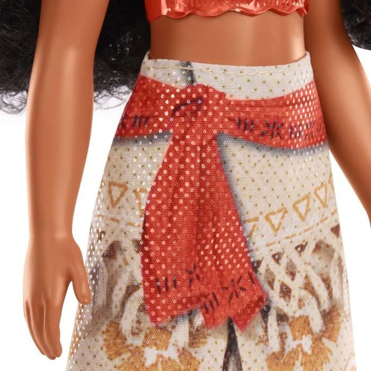 Una muñeca con top y falda rojos. La falda tiene un cinturón rojo y un patrón de símbolos. Se ven los brazos de la muñeca.