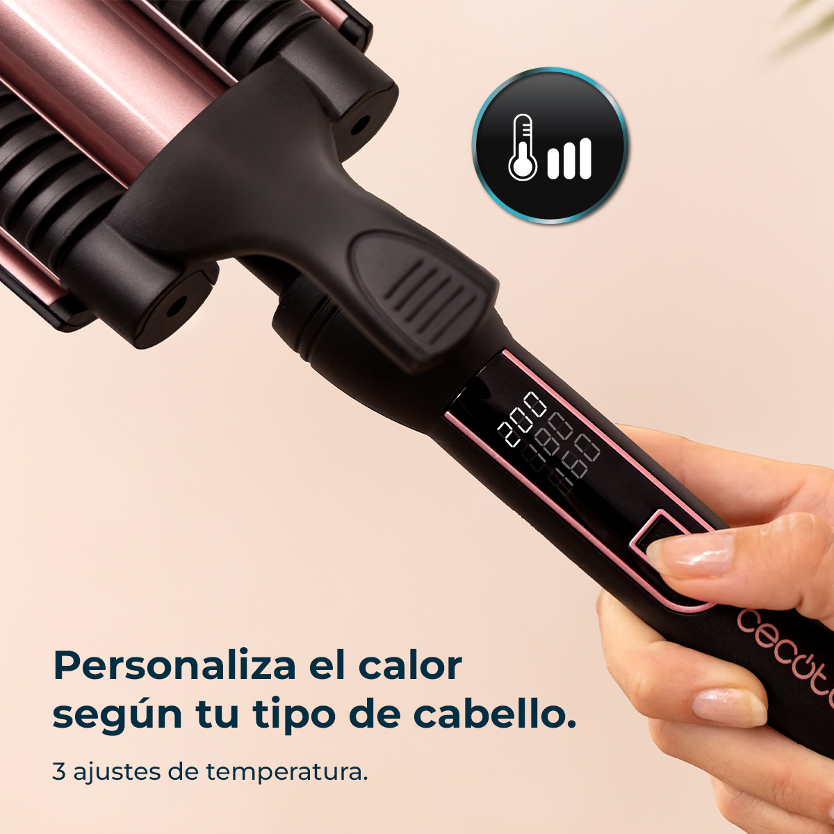Una mano sostiene una plancha para el cabello negra y oro rosa. Tiene una pantalla digital que muestra los ajustes de temperatura.
