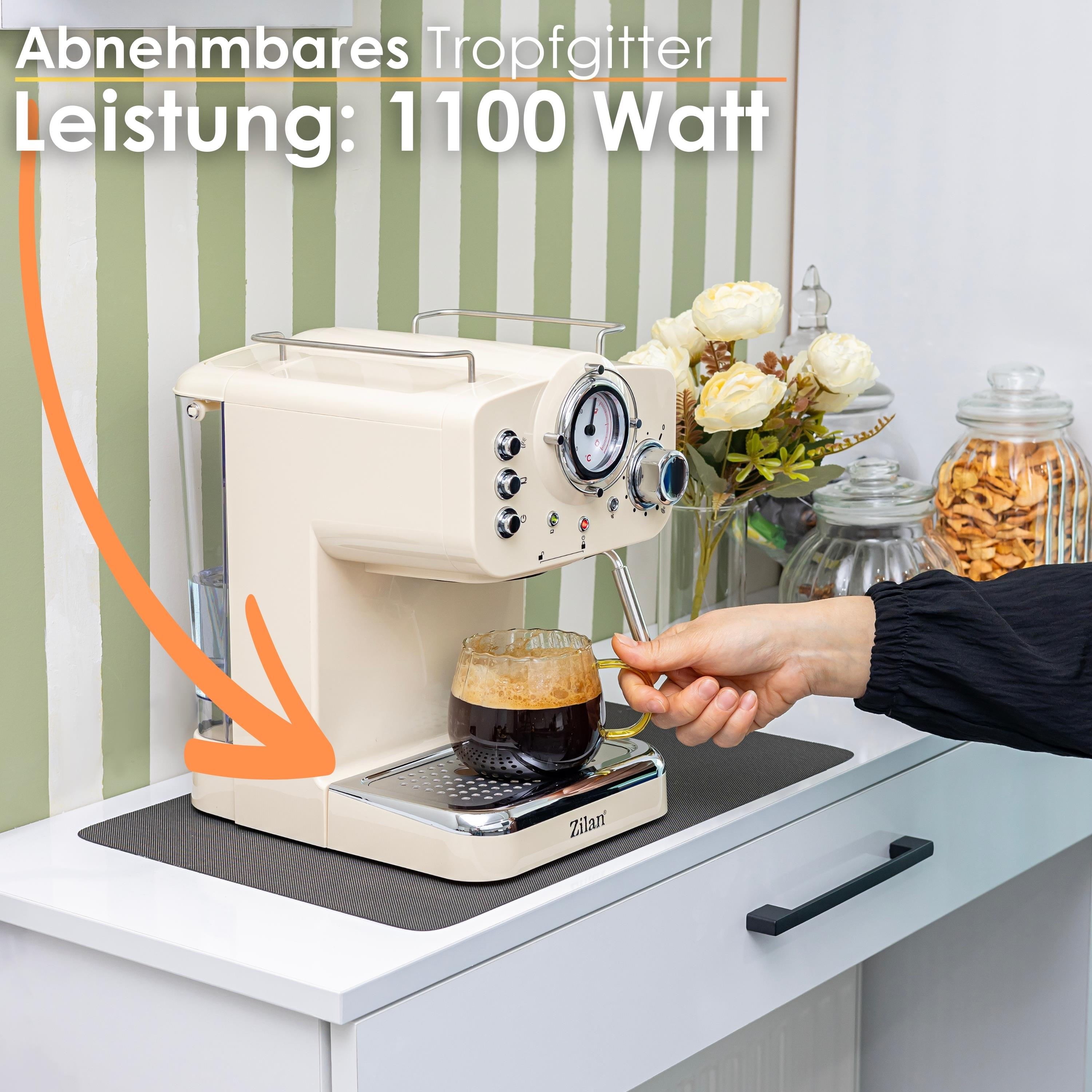 Bardak içinde kahve bulunan krem rengi espresso makinesi. El tutamağı tutuyor. Arka planda çiçekler ve kavanozlar.