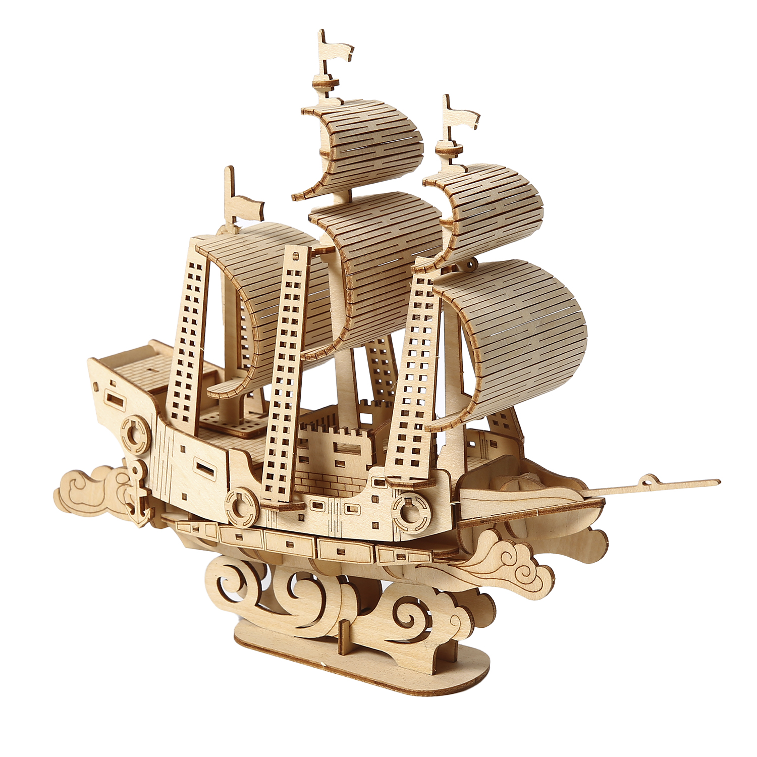 Un modello di nave in legno con vele e bandiere. La nave poggia su una base con dettagli a forma di onda, tutto in legno chiaro.