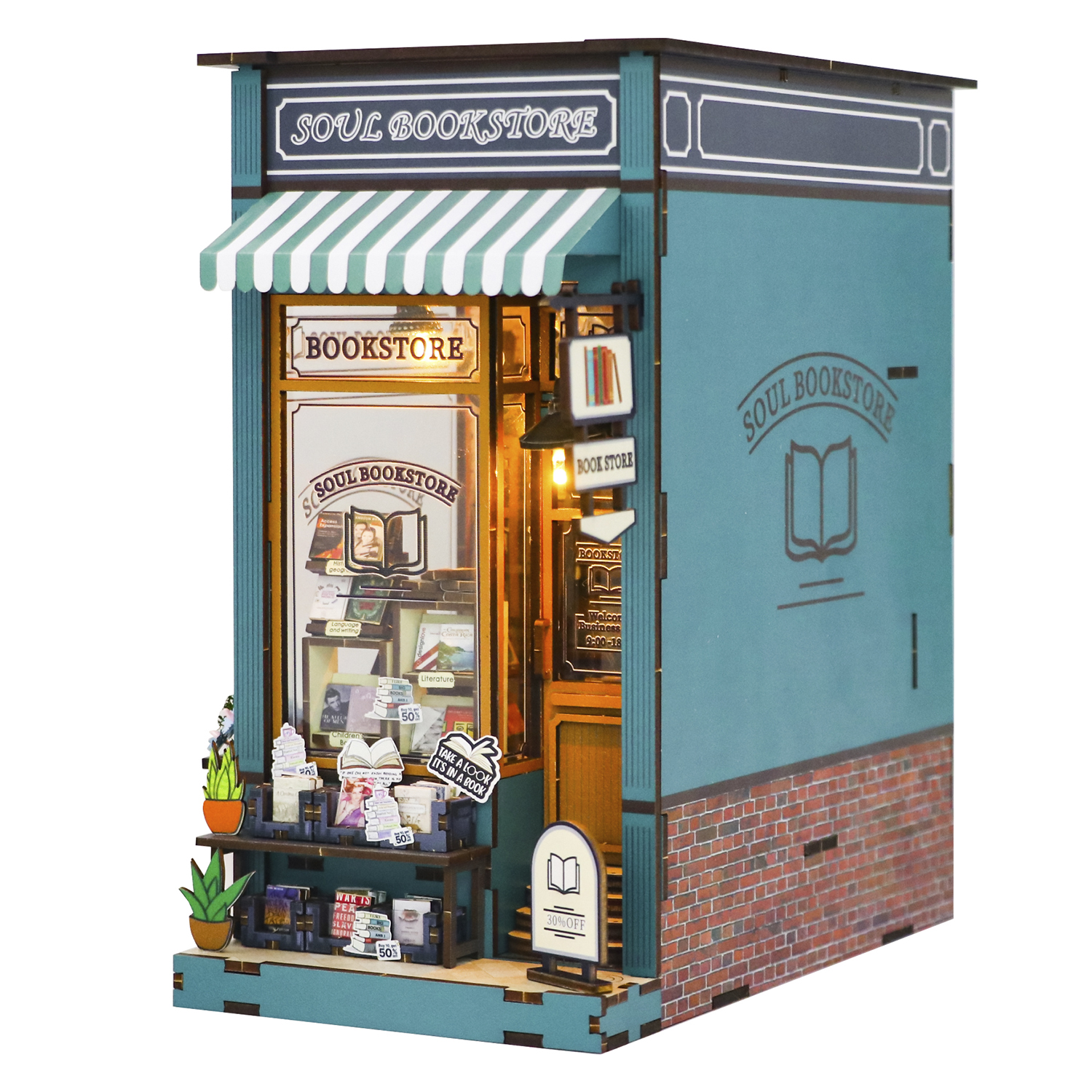 Modello di libreria in miniatura con tenda a strisce verdi e bianche. Ha insegne, libri e una facciata in mattoni.