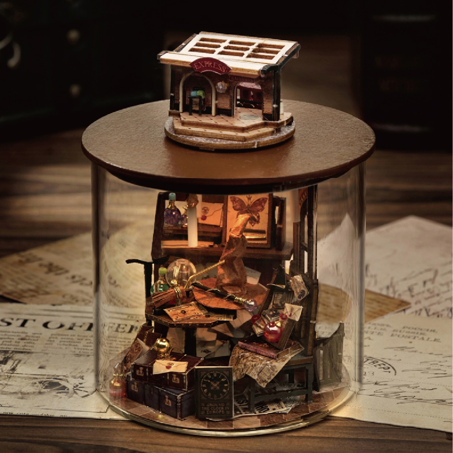 Una scena in miniatura all'interno di un barattolo di vetro. Include un negozio, libri, un cappello, un tavolo e altri oggetti decorativi.