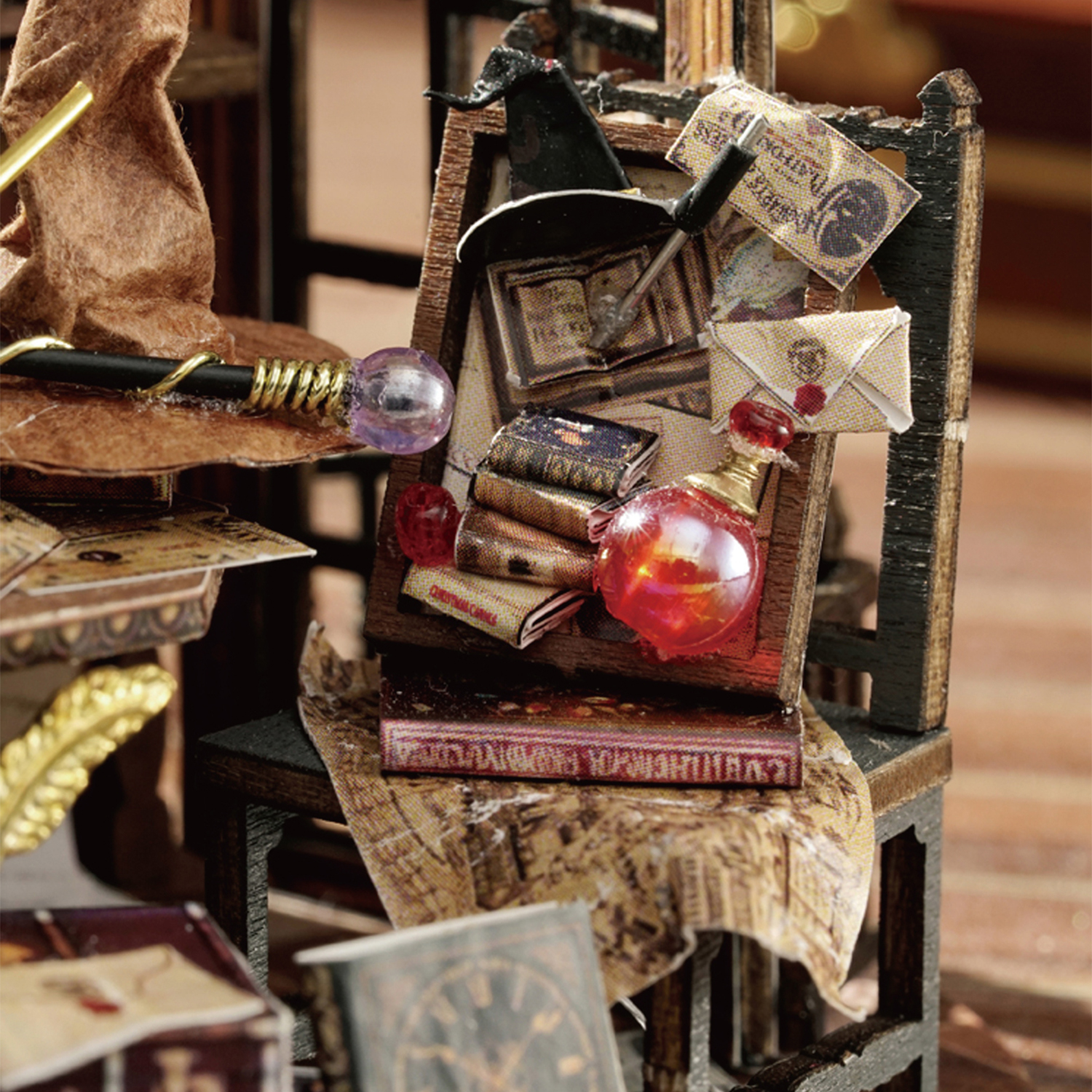 Scena in miniatura con libri, bottiglia di pozione, cappello e bacchetta su una sedia. Illuminazione calda. Artigianato dettagliato.