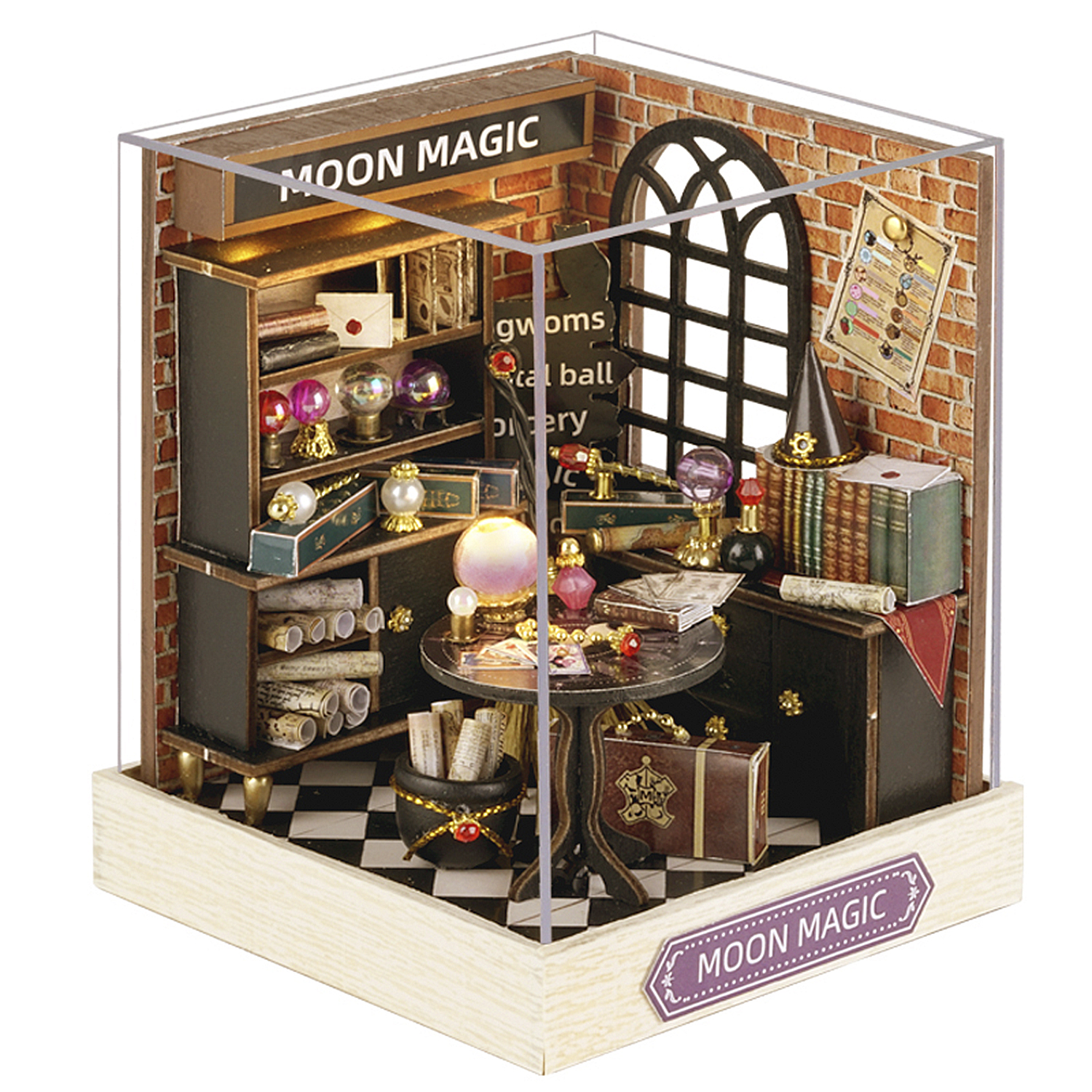 Negozio di magia in miniatura in una teca di vetro. Libri, sfere di cristallo, un tavolo e un calderone sono presenti. Il cartello dice "MOON MAGIC".