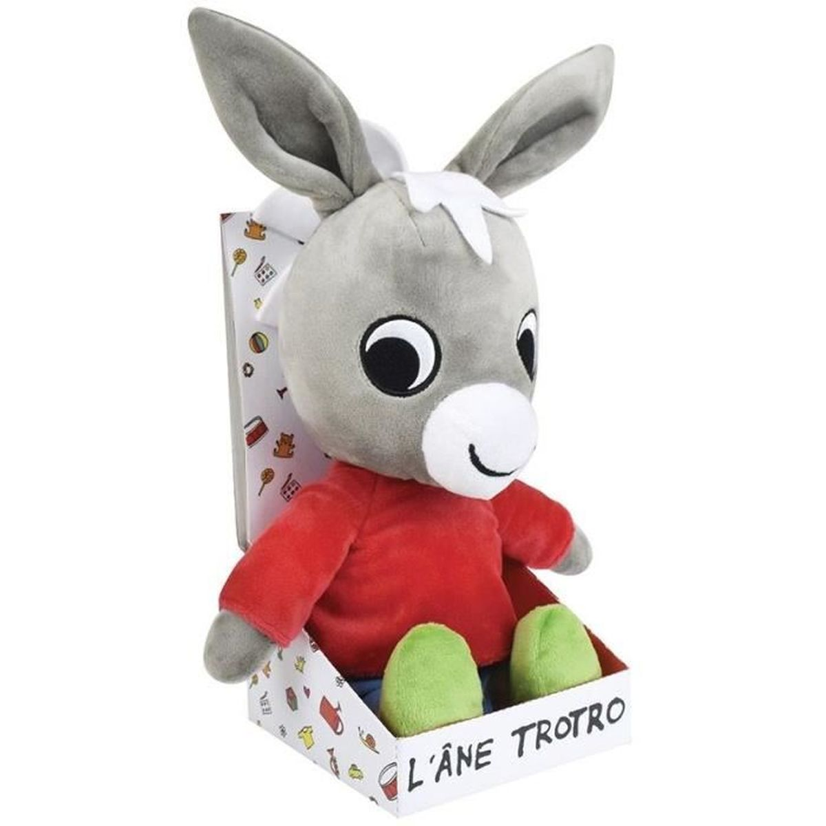 Ein Stofftier-Esel in einer Box. Er hat graues Fell, große Augen, ein rotes Hemd, grüne Füße und lange Ohren. Auf der Box steht 'L'Âne Trotro'.