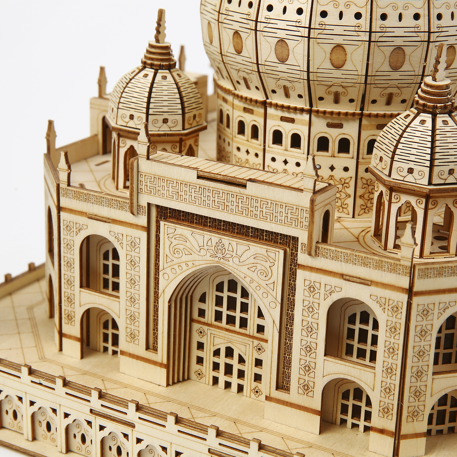 Un modello in legno dettagliato del Taj Mahal. Mostra intagli intricati, cupole multiple, archi, finestre e un'architettura dettagliata.