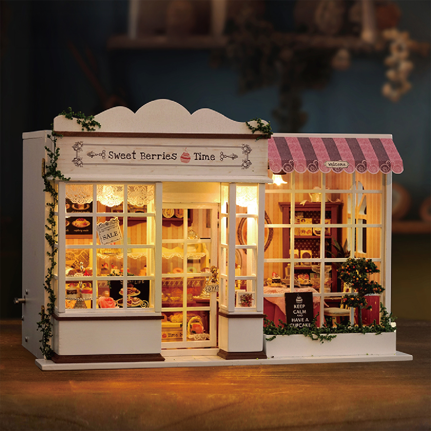 Miniatura di panetteria con insegna 'Sweet Berries Time', esposizione di torte e tenda a strisce rosa. Include un alberello e un cartello con scritto 'Keep Calm'.