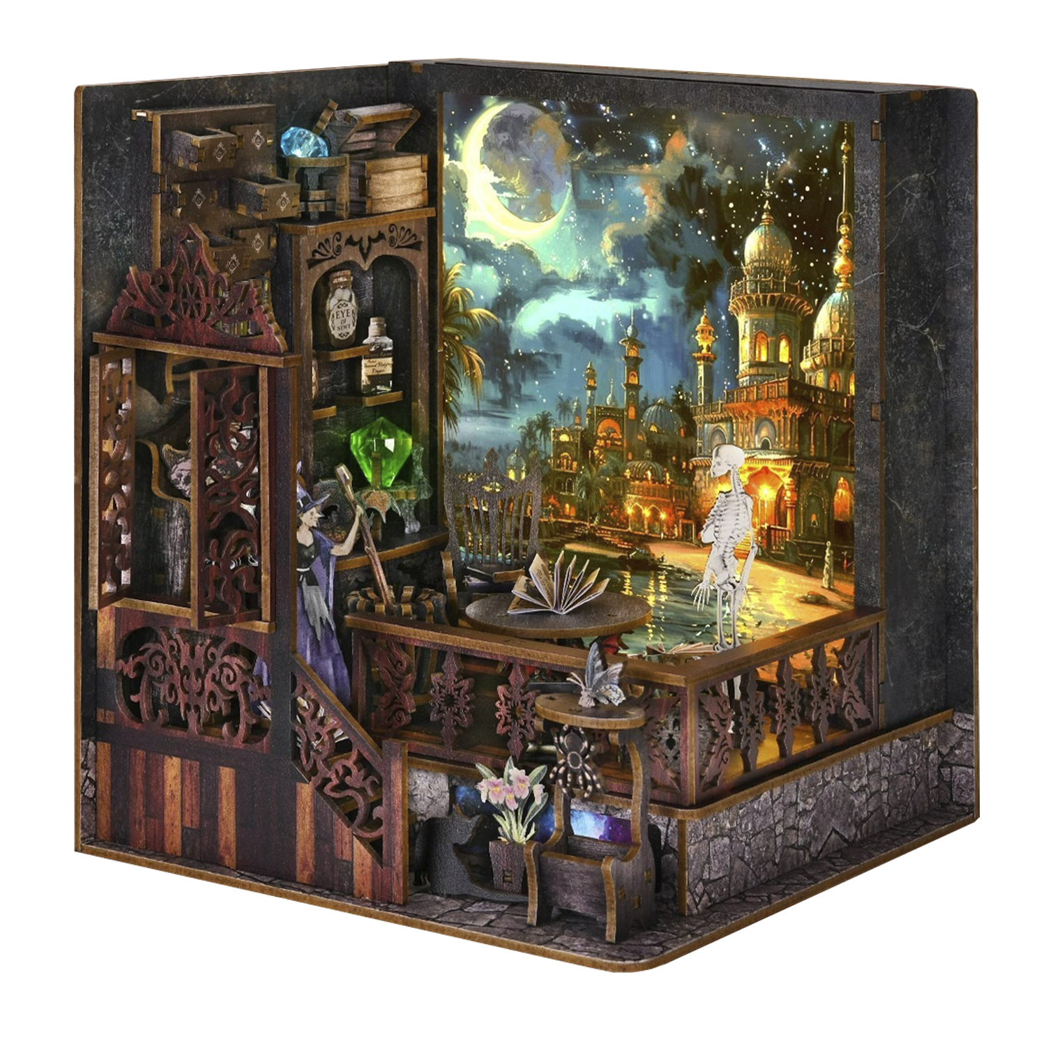 Una scena in miniatura di legno con una strega, uno scheletro e un paesaggio urbano sotto un cielo stellato. Libri e gemme visibili.