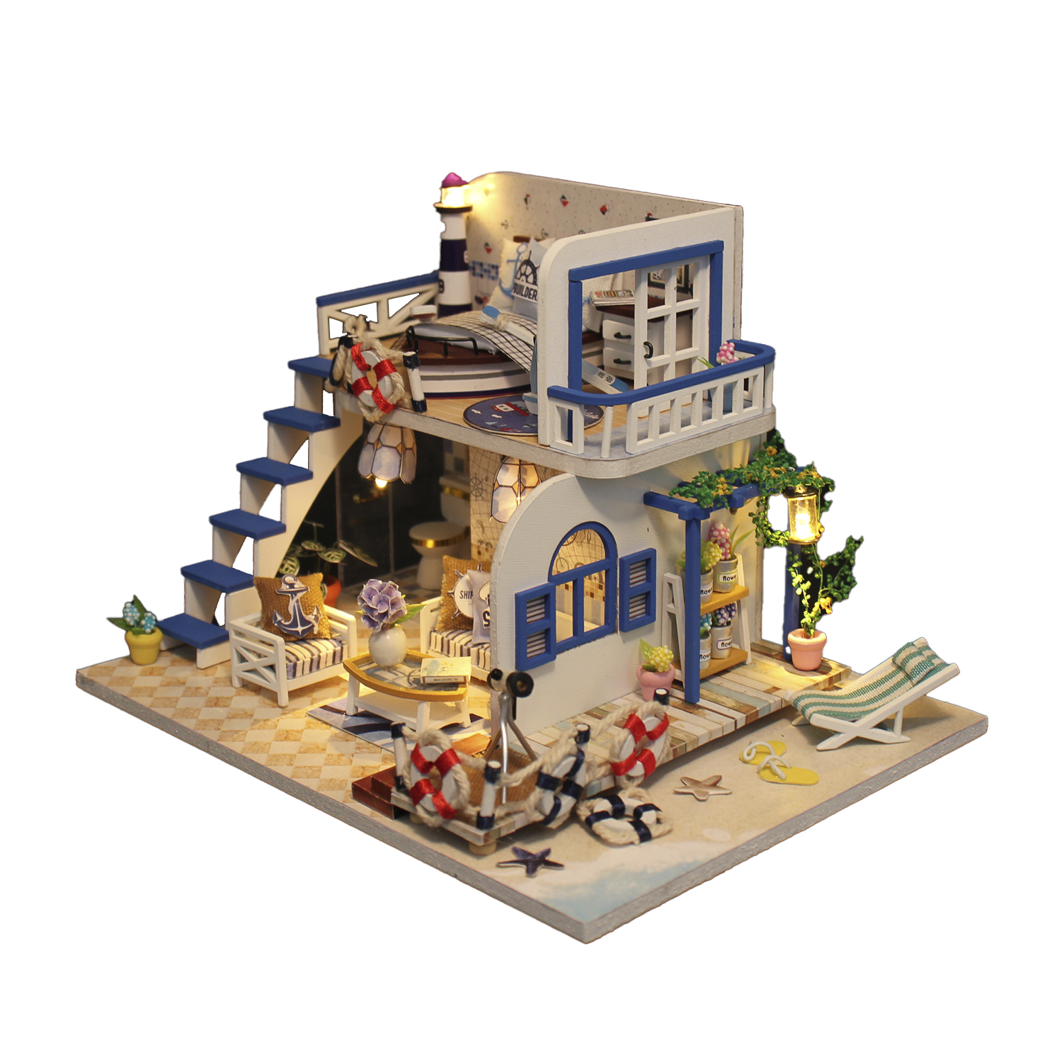 Miniatur-Strandhausmodell mit blau-weißen Akzenten, einem Leuchtturm und Strandelementen wie Rettungsringen und einem Deckchair.