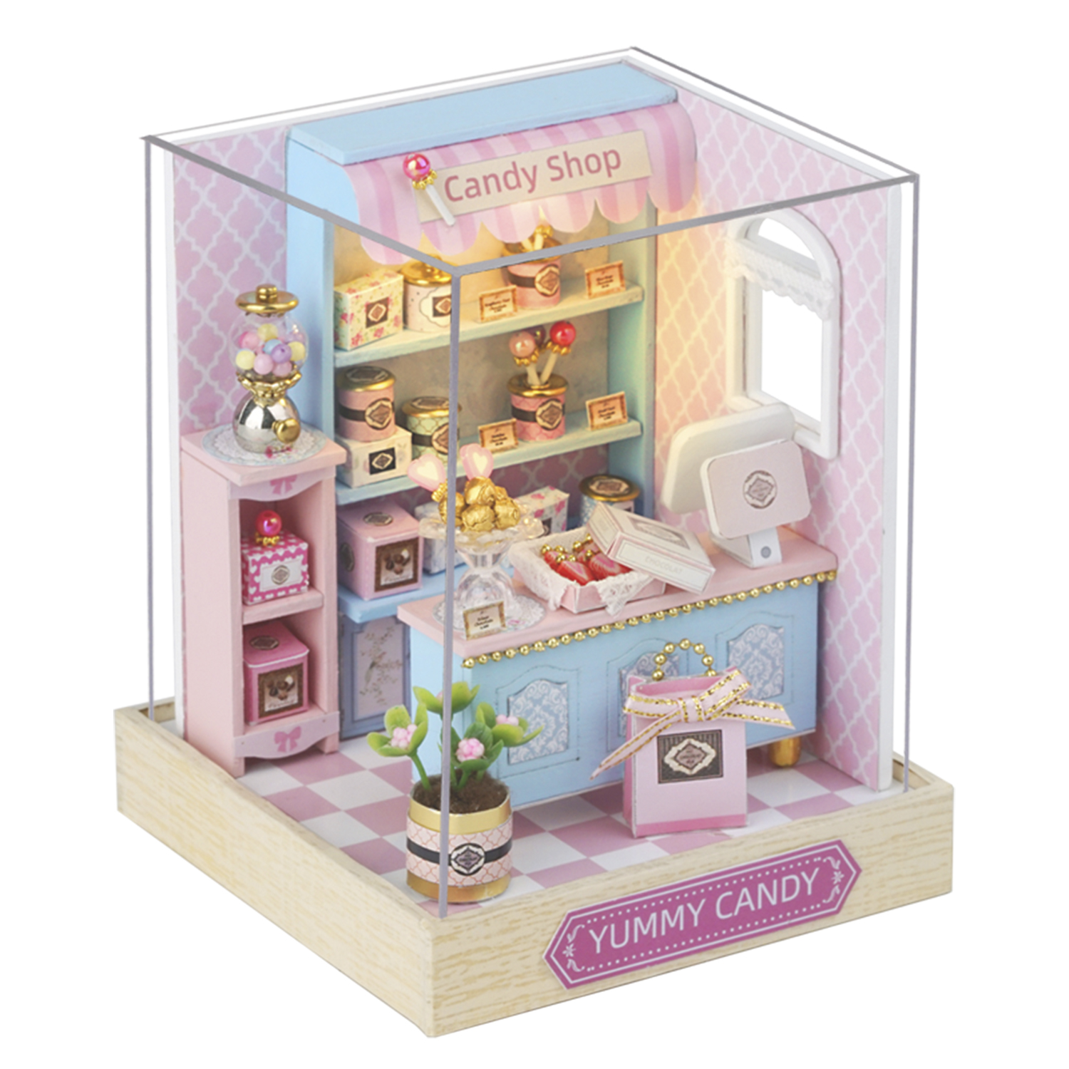 Miniatur-Süßwarenladen mit rosa, blauen und goldenen Akzenten. Enthält Regale mit Leckereien, einen Kaugummiautomaten und eine Kasse.