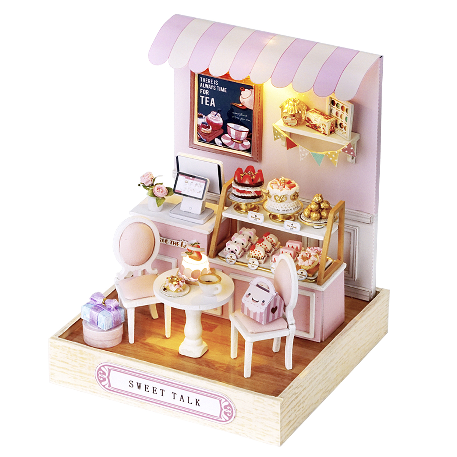 Mini negozio di dolci con torte, pasticcini e un tavolino. Schema di colori rosa e bianco. L'insegna recita 'Sweet Talk'.