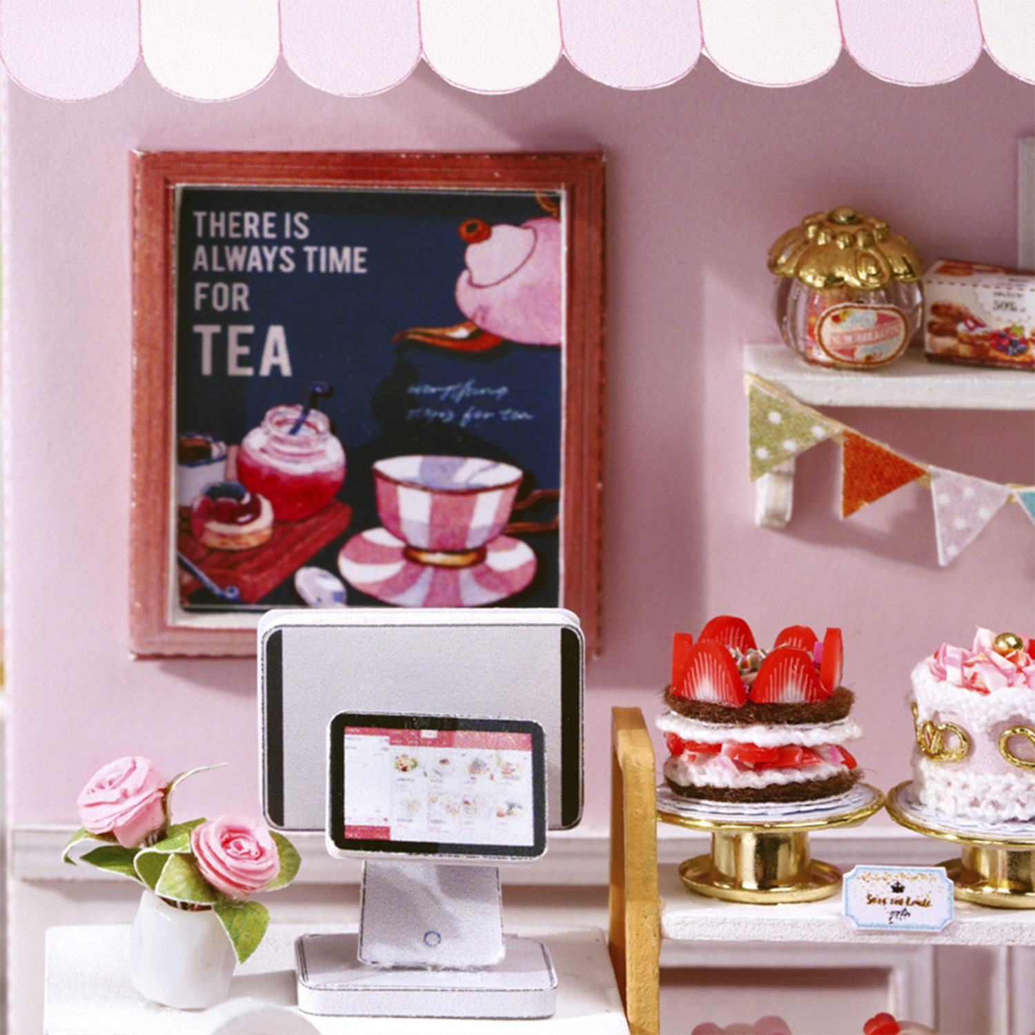 Mini negozio di tè con torte, insegna del tè e registratore di cassa. Rose rosa in un vaso sul bancone. Scena in miniatura.