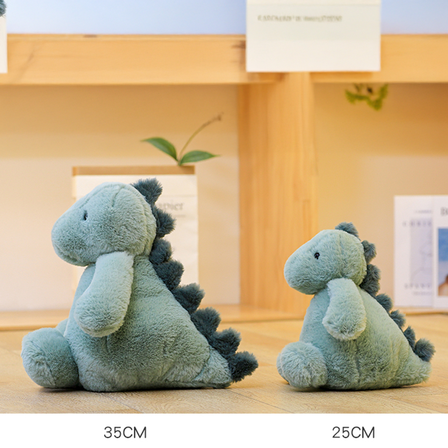Due giocattoli a forma di dinosauro di peluche verde di diverse dimensioni sono su una superficie di legno. Dimensioni 35 cm e 25 cm.
