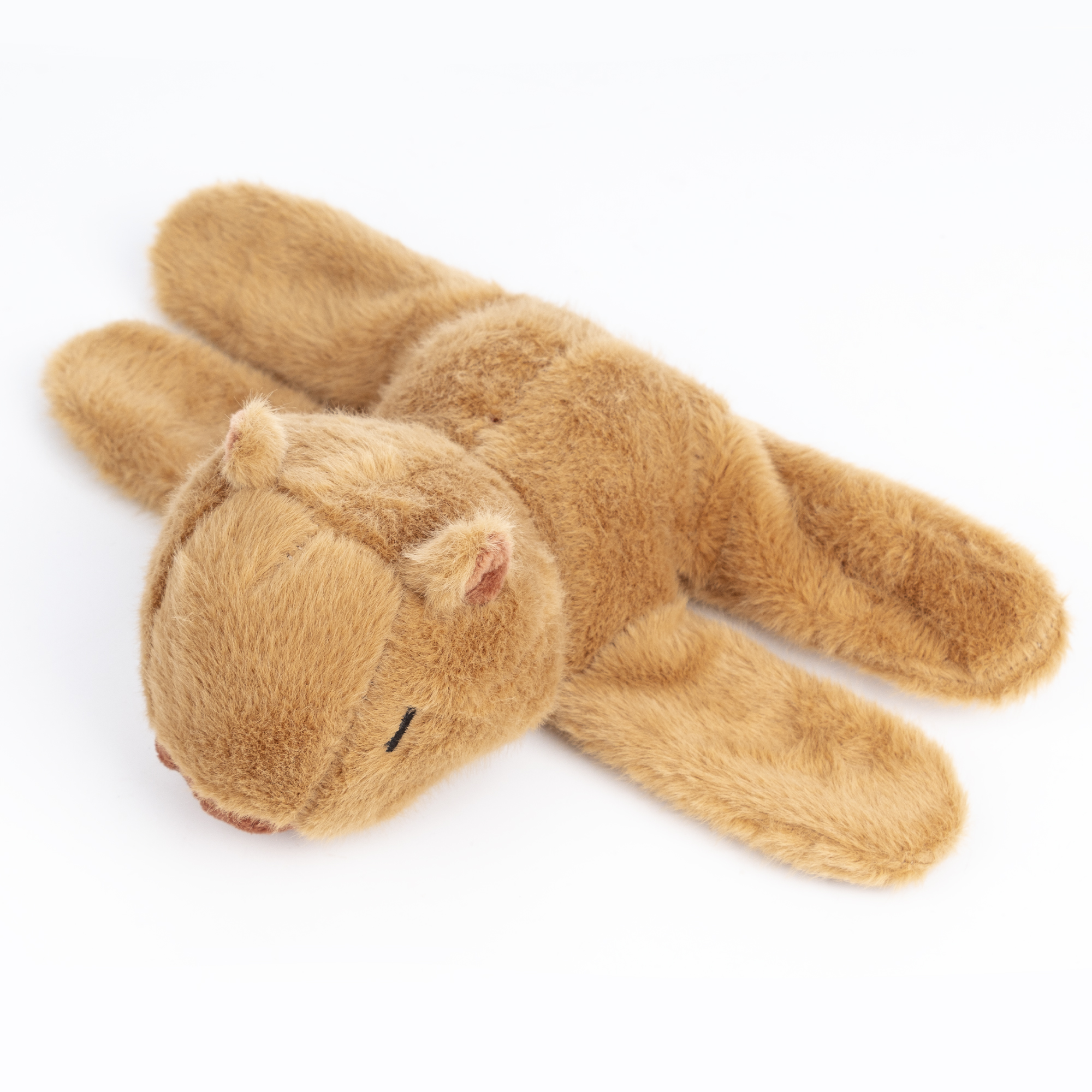 Un juguete de peluche marrón con forma de ardilla, acostado sobre una superficie blanca.