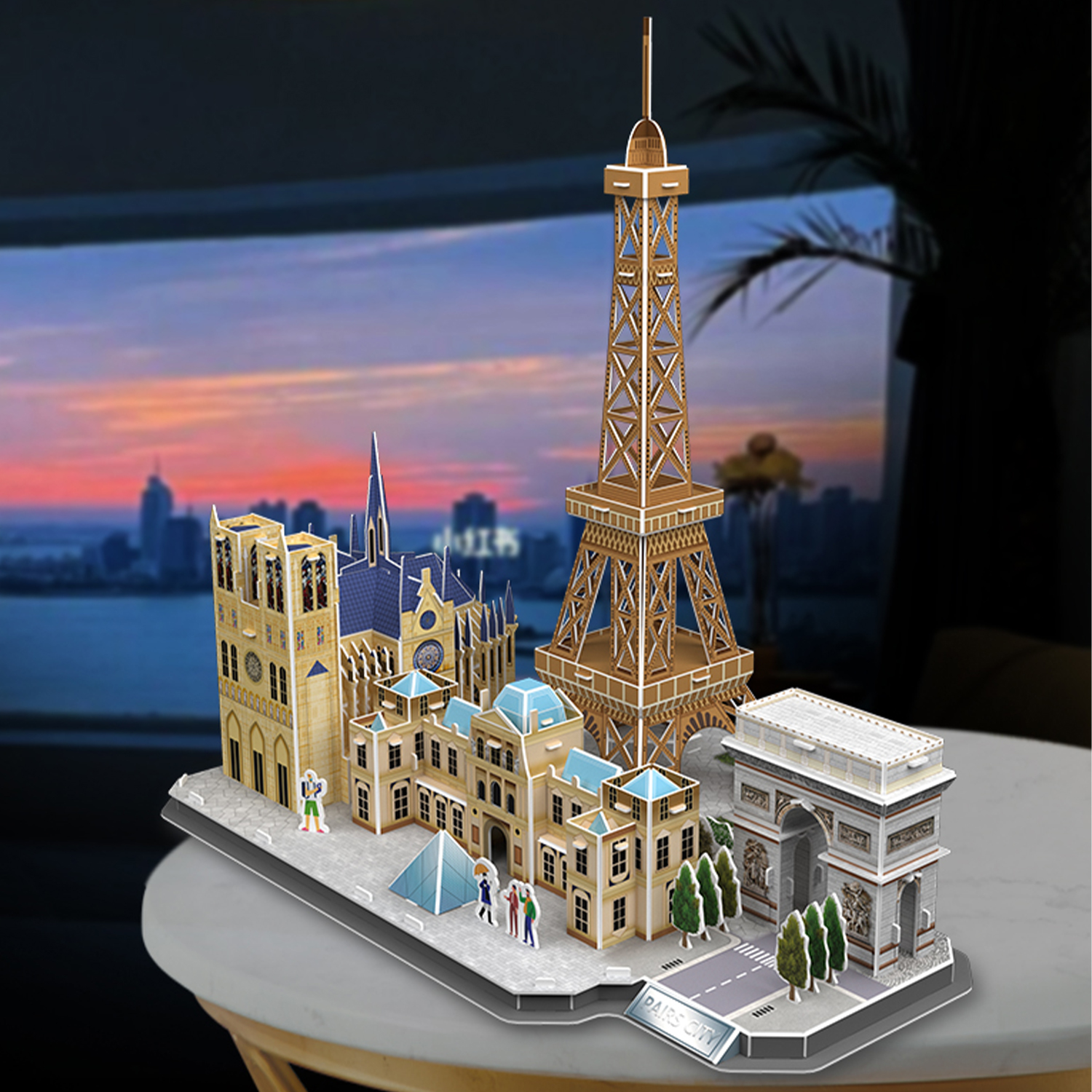 Un modello di Parigi con la Torre Eiffel, l'Arco di Trionfo e altri edifici. Un tramonto è visibile sullo sfondo.