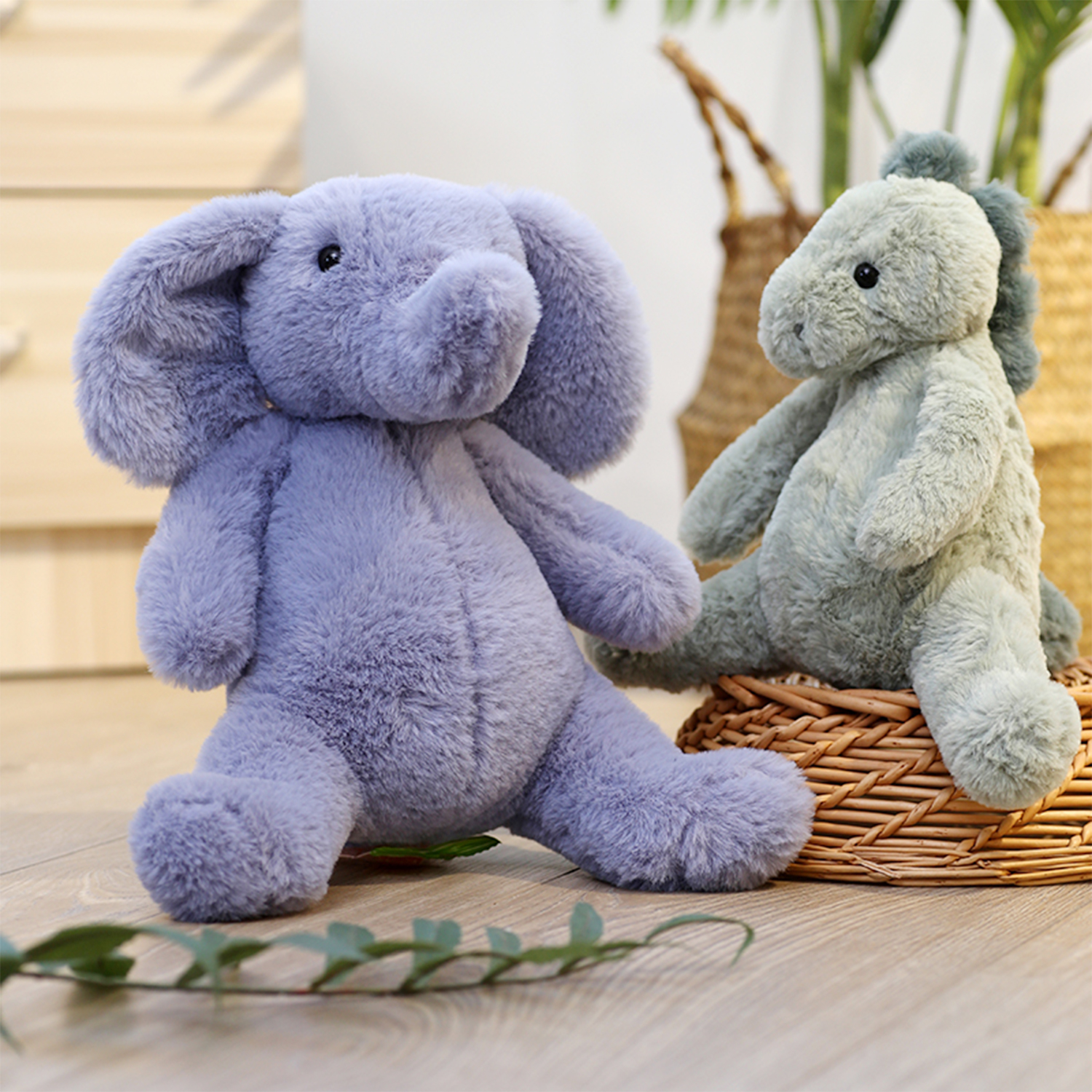 Un elefante di peluche grigio e un dinosauro di peluche verde sono seduti su un pavimento di legno vicino a un cestino di vimini con piante.
