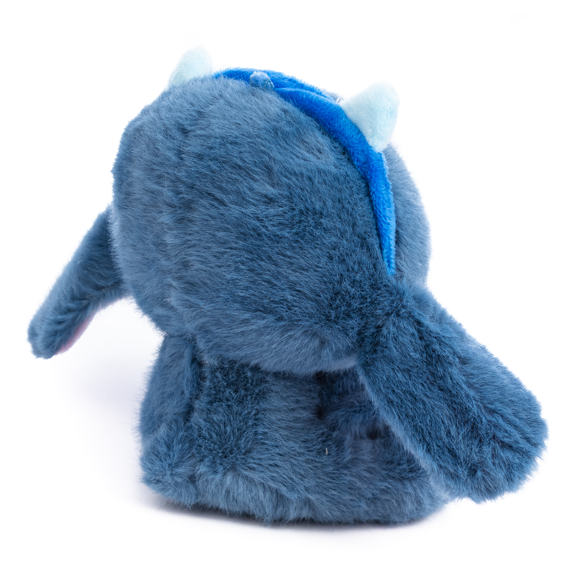 Un peluche blu, simile a un personaggio dei cartoni animati, è su sfondo bianco. Ha grandi orecchie ed è girato.