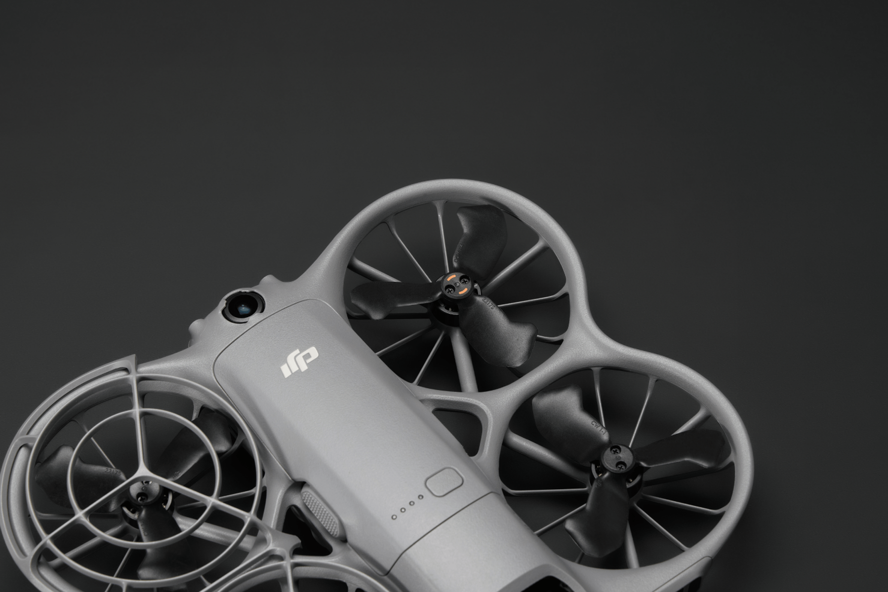 Eine graue DJI-Drohne mit vier Propellern vor dunklem Hintergrund. Die Drohne ist fokussiert, zentriert und gut beleuchtet.