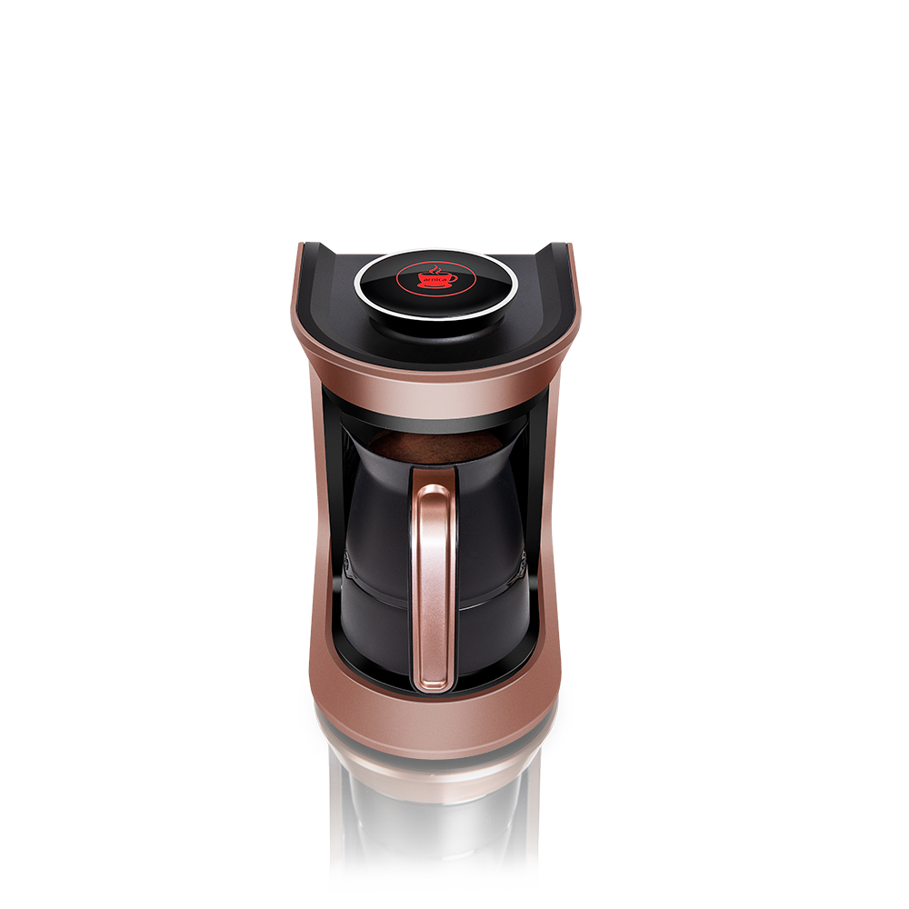 Eine roségoldene und schwarze elektrische Kaffeemaschine auf weißem Untergrund. Sie hat einen roten Knopf mit einem Kaffeetassen-Symbol.