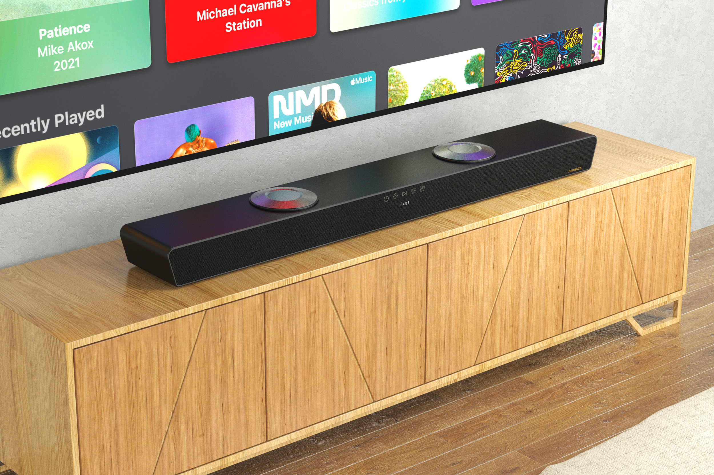 Una barra de sonido negra sobre un mueble de madera, con un televisor que muestra aplicaciones de música. La barra de sonido tiene dos luces circulares.