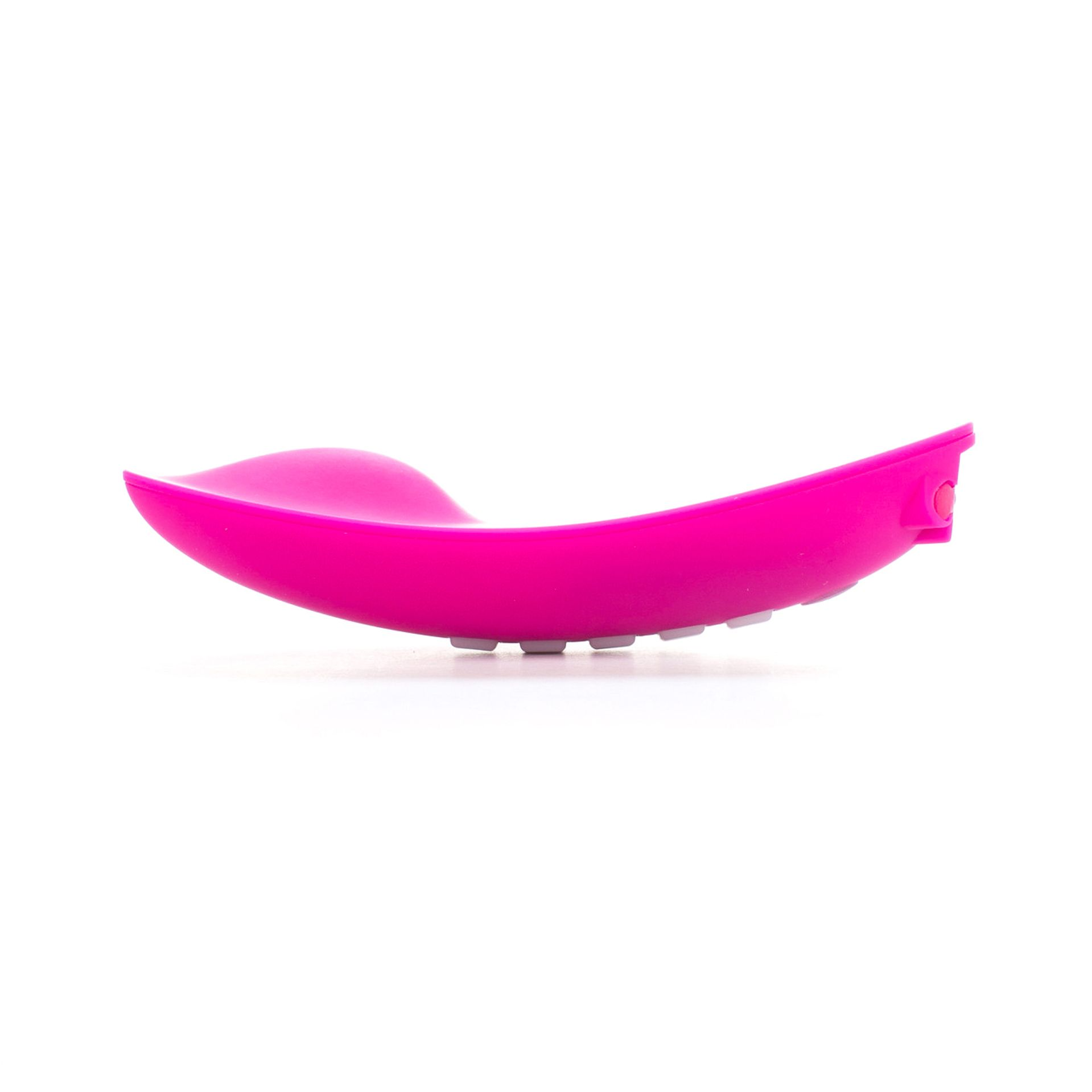 Ein rosa, geschwungenes, glattes Objekt auf weißem Hintergrund. Es hat eine runde Form mit weißen Knöpfen.