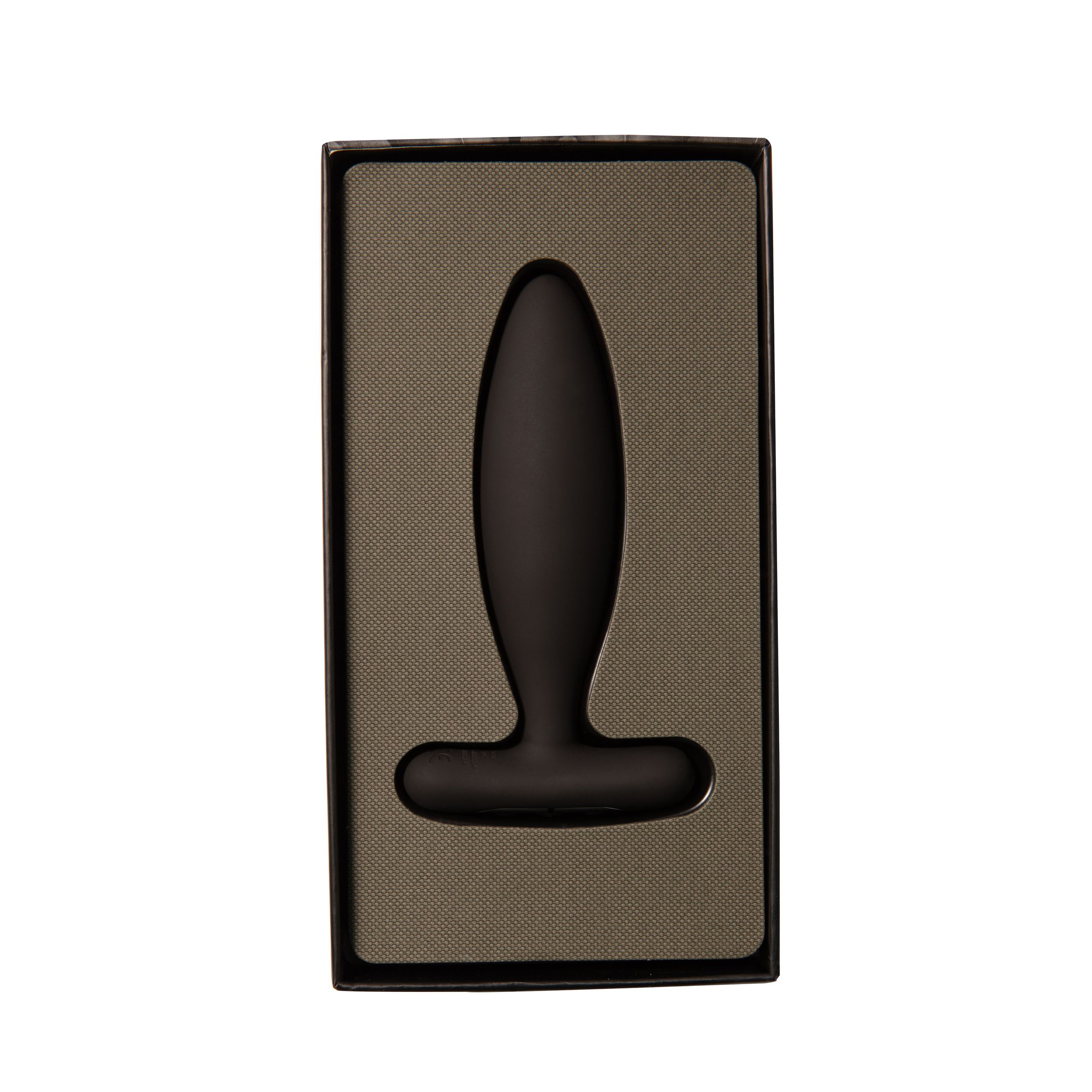 Ein schwarzer Anus-Plug in einer schwarz-beigen Schachtel, vor weißem Hintergrund.