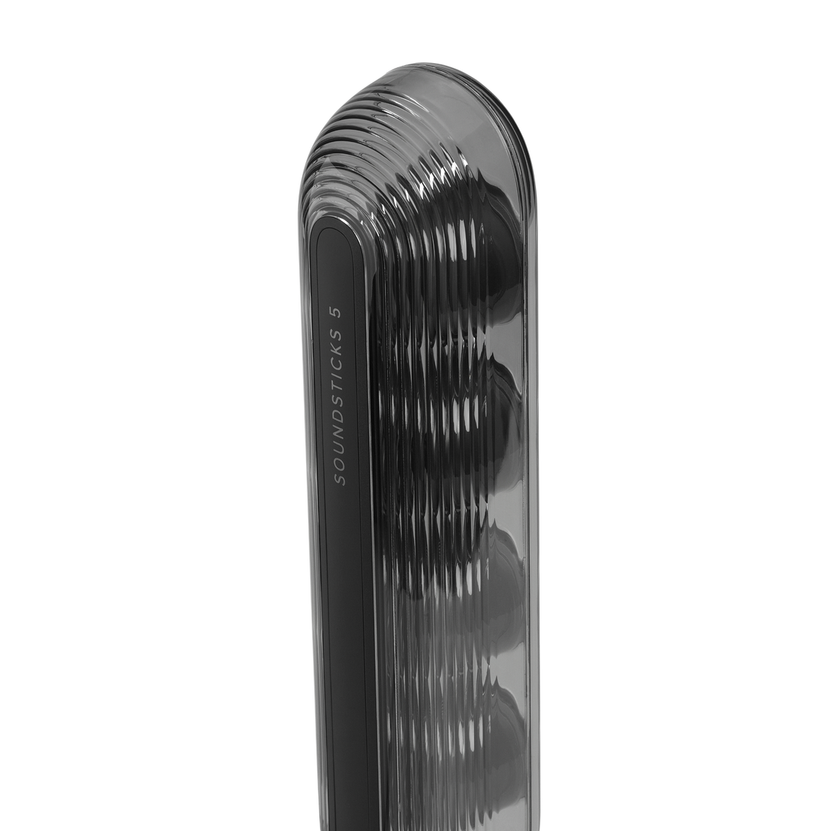 Nahaufnahme eines Soundsticks 5-Lautsprechers. Er hat eine glänzende, gerippte Außenseite. Der Lautsprecher ist schwarz mit dem Text "SOUNDSTICKS 5" an der Seite.