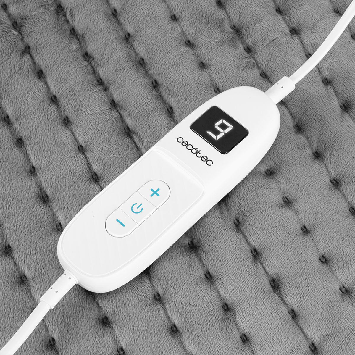 Un control blanco de almohadilla térmica con pantalla digital '9'. Botones más, menos y encendido/apagado visibles.