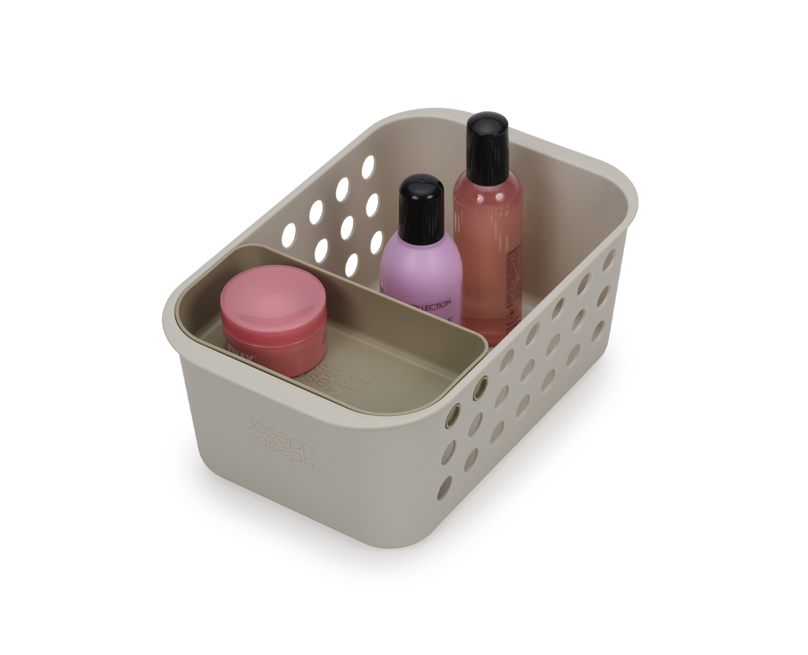 Un organizador de plástico beige contiene un tarro rosa, una botella morada y una botella rosa con tapas negras. El organizador está sobre una superficie blanca.