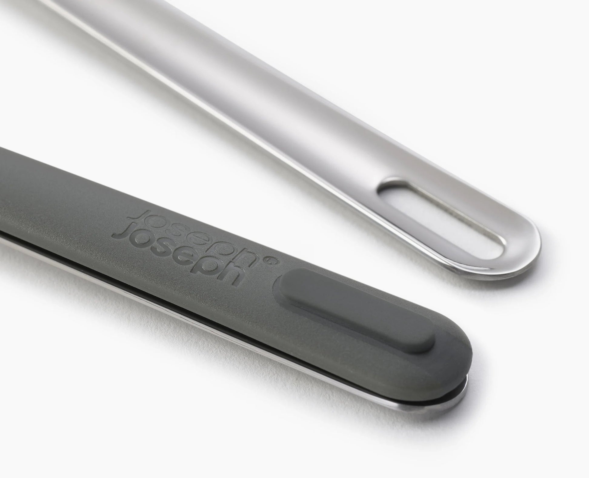 Primer plano de dos utensilios de cocina. Uno es gris con el logotipo de Joseph Joseph, el otro es plateado con un agujero.