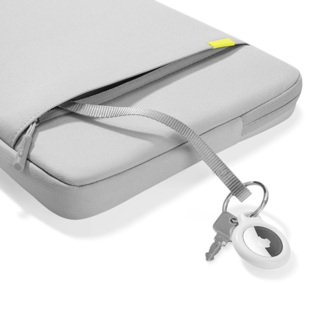 Een grijze laptoptas met rits, een sleutel en een Apple AirTag bevestigd aan een koord. Een gele accent is zichtbaar.
