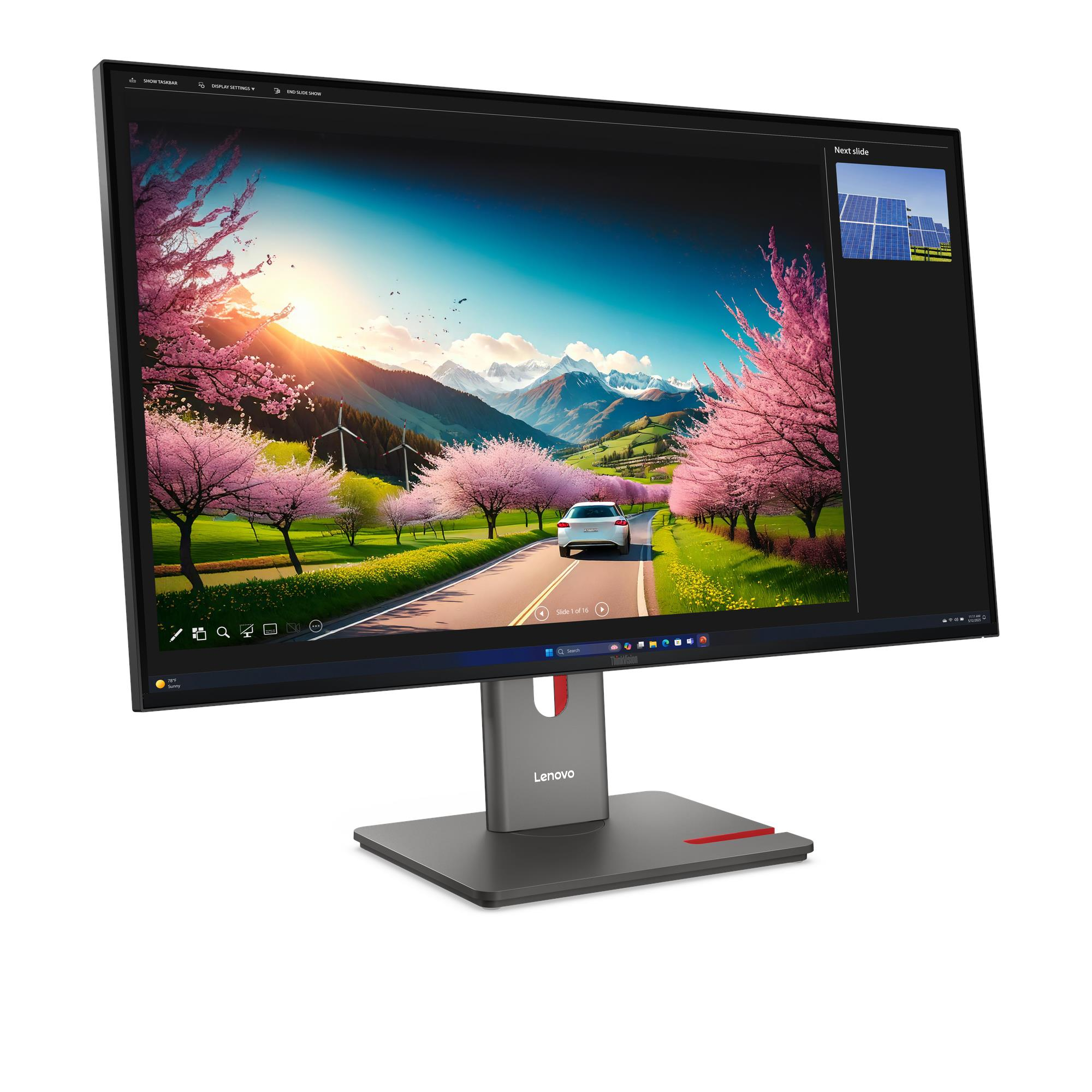Een Lenovo-monitor toont een schilderachtig uitzicht op een weg met een auto, omgeven door roze bloesem en bergen.