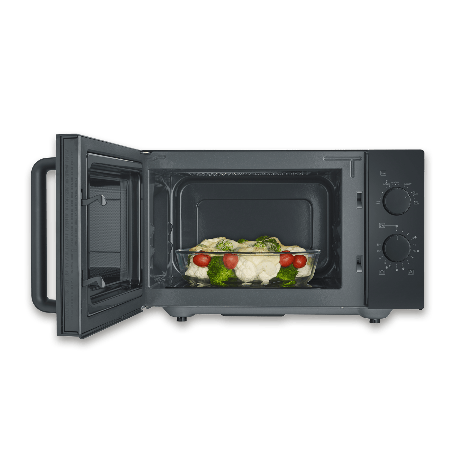 Offene Mikrowelle mit Essen. Glasschale mit Tomaten, Brokkoli und Blumenkohl. Dunkelgraue Mikrowelle auf grünem Hintergrund.