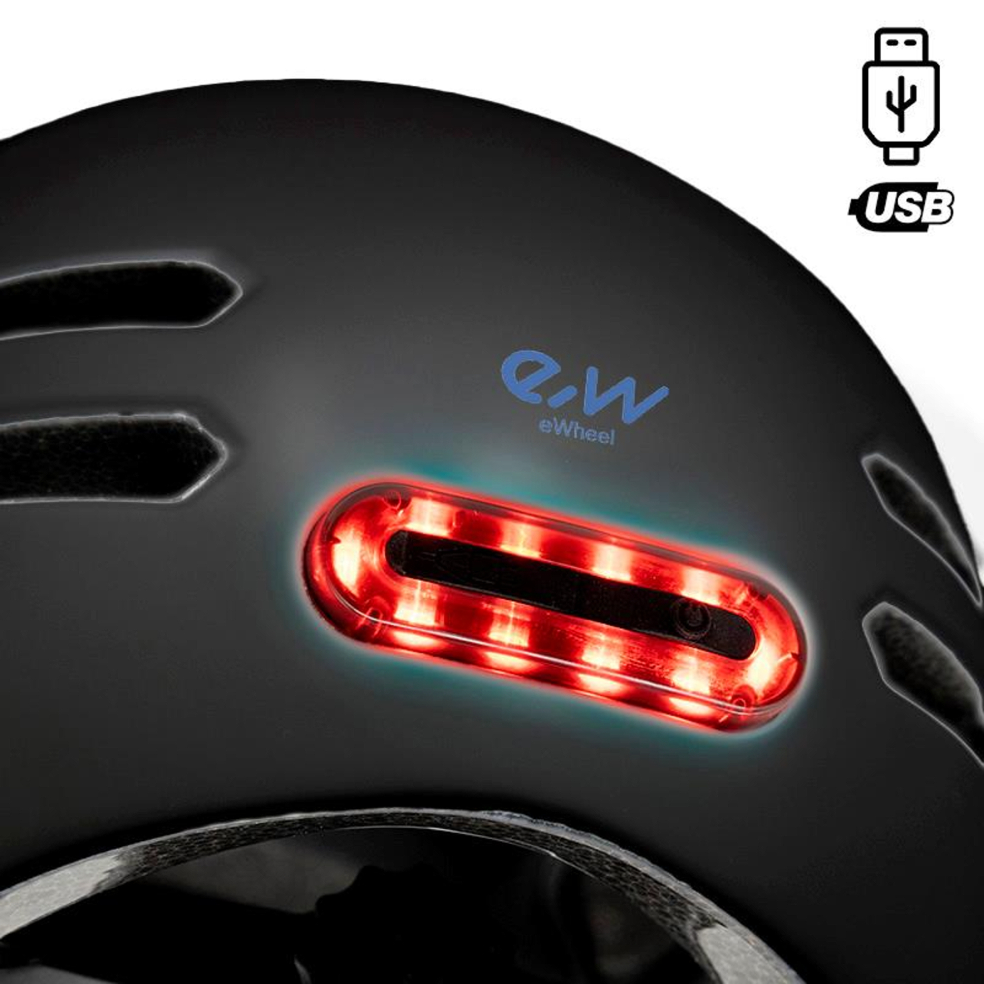 Primer plano de un casco negro con luz roja, el logotipo de e-wheel y un símbolo USB. El casco tiene ventilaciones.