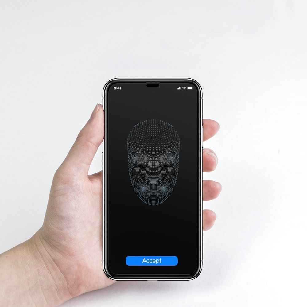 Una mano tiene uno smartphone che mostra una scansione del viso. Lo schermo mostra una griglia facciale blu con un pulsante 'Accetta'.
