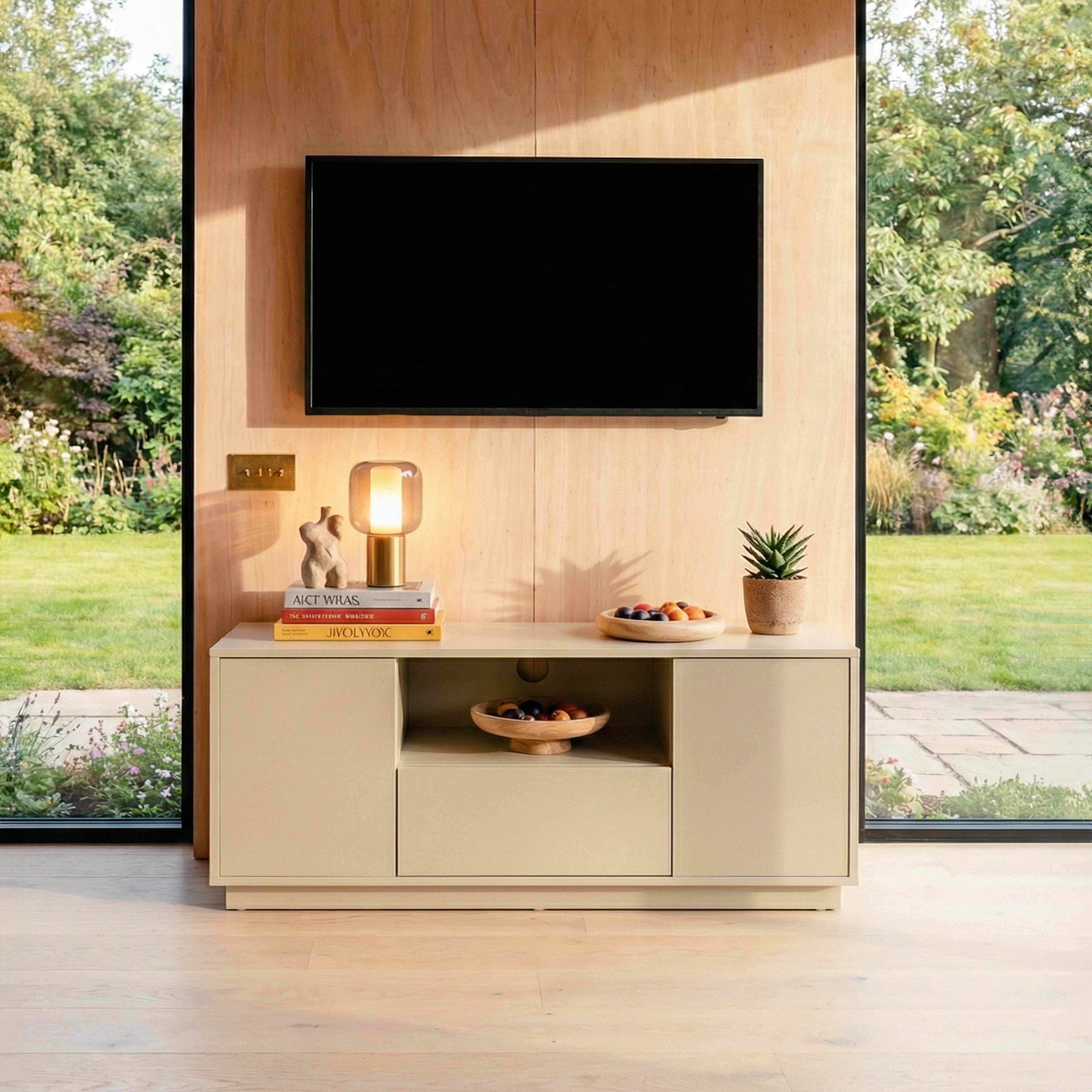 Modernes Wohnzimmer mit Fernseher, Schrank und Blick auf einen Garten.