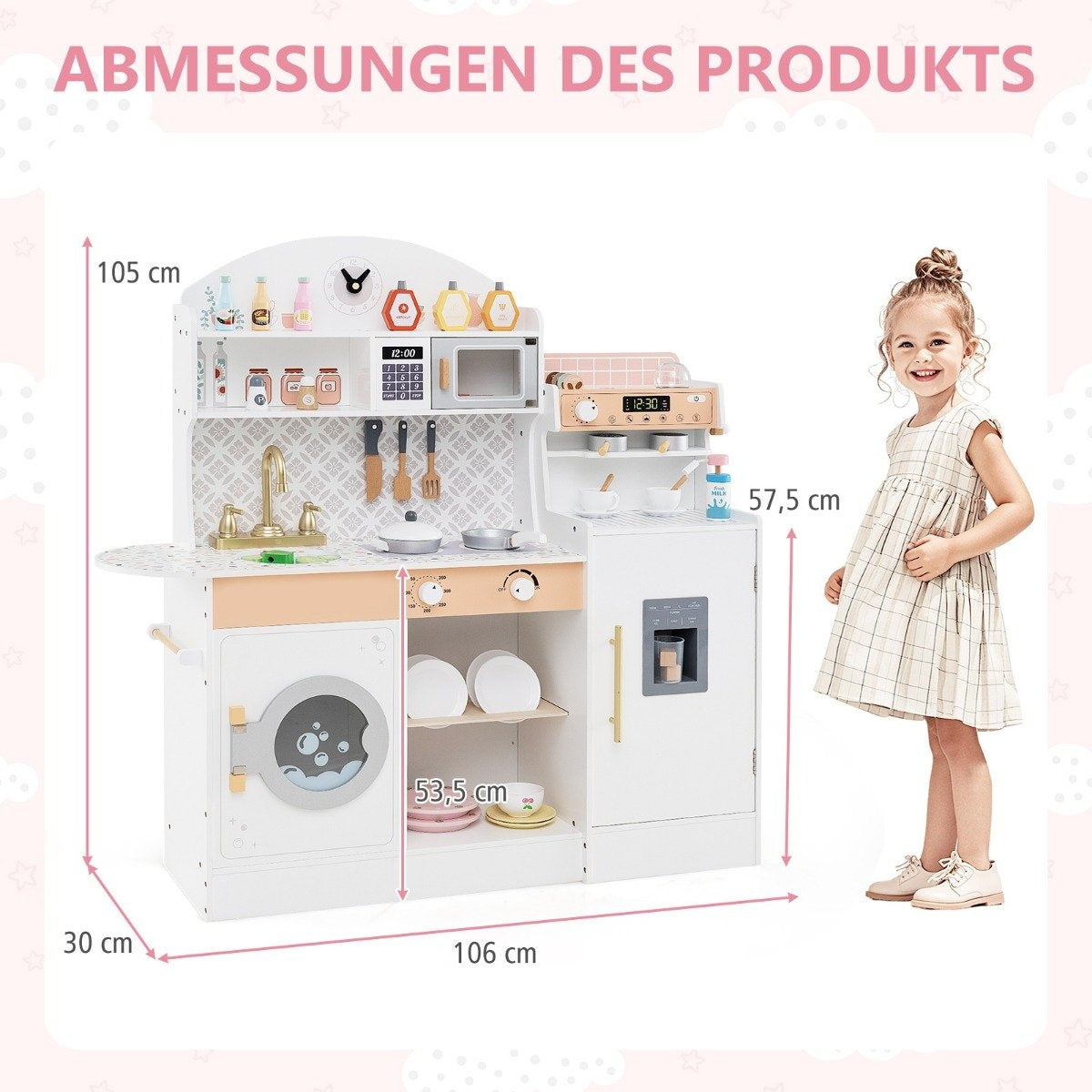 Una niña está junto a una cocina de juguete. La cocina es blanca, tiene cocina, fregadero, microondas y nevera con medidas.