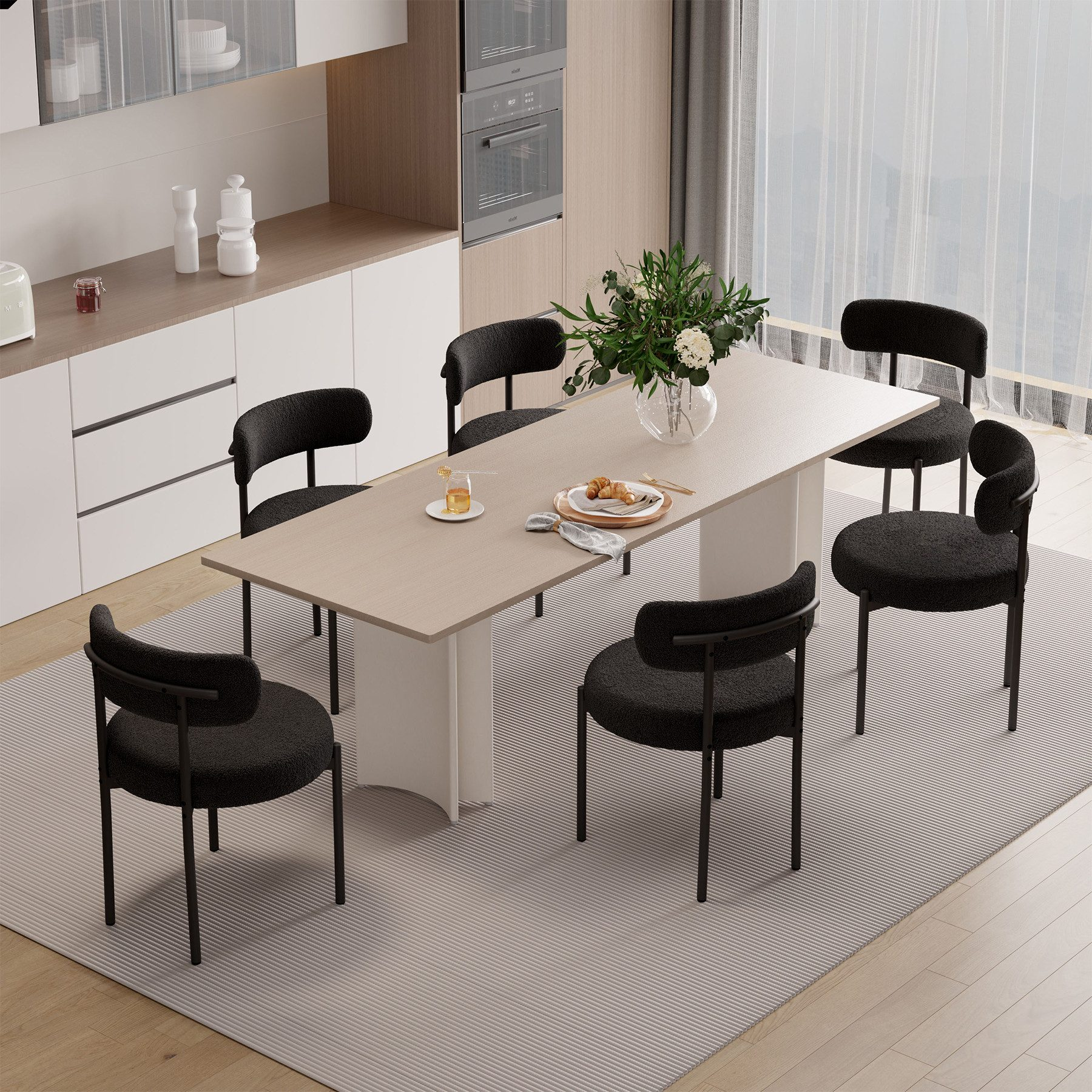 Ein Esszimmer mit Tisch, sechs schwarzen Stühlen und einem Blumengesteck. Küchenschränke und ein Fenster sind sichtbar.