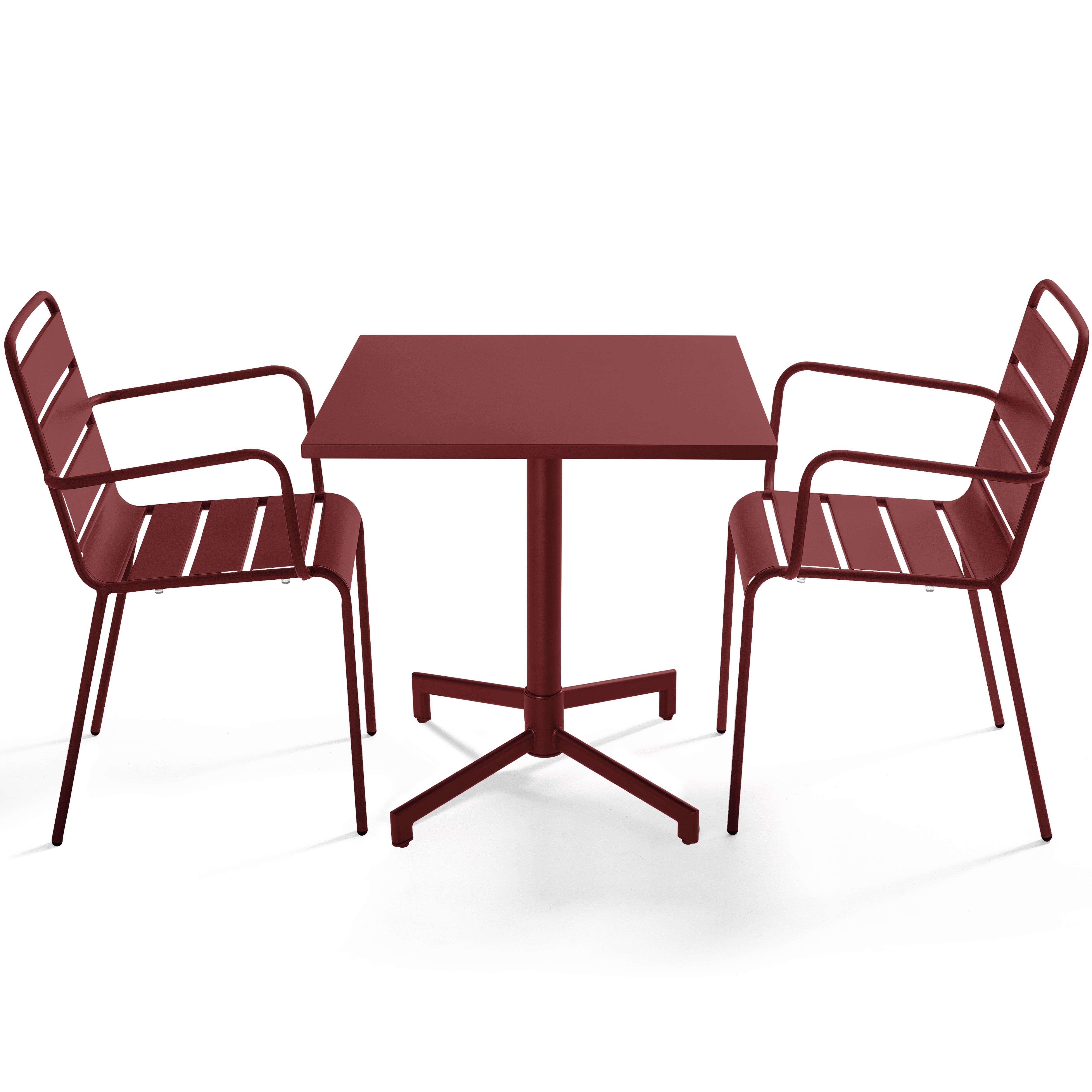 Ein maroonfarbener Tisch und zwei Stühle. Der Tisch hat eine quadratische Oberseite und ein zentrales Bein. Stühle haben Armlehnen und Lattenroste.