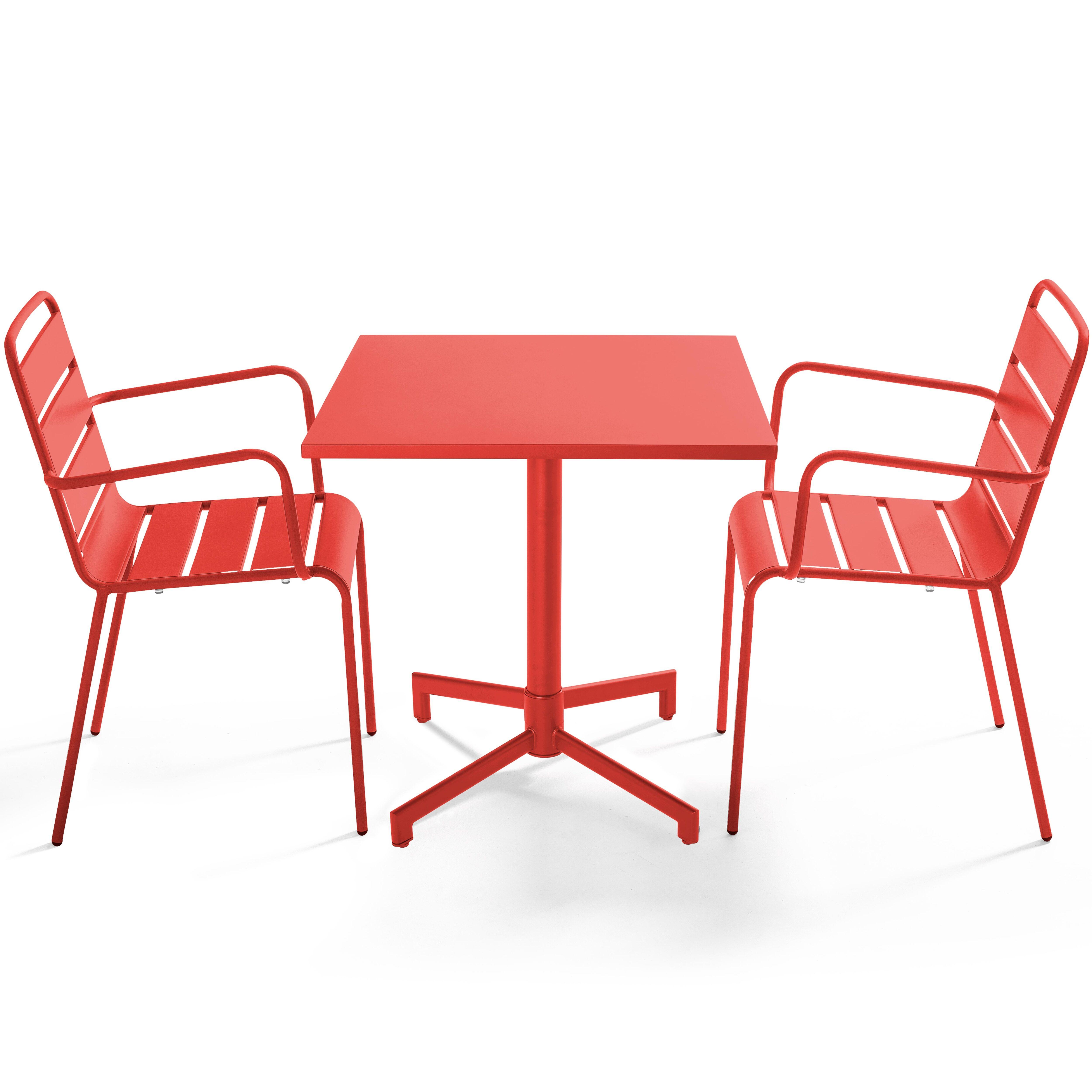 Ein roter quadratischer Tisch mit zwei passenden Sesseln auf weißem Hintergrund. Die Möbel sind aus Metall.